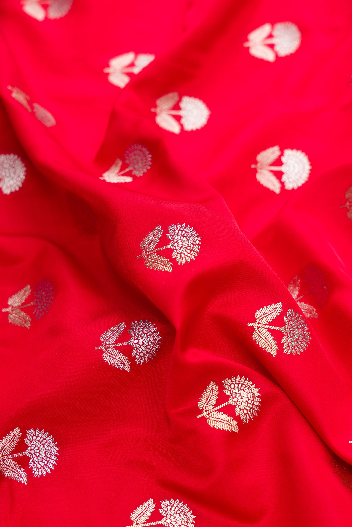 Close up of Red Dual Tone Blended Banarasi Silk Saree with Zari Butta on the body and Zari Border.  displaying folds