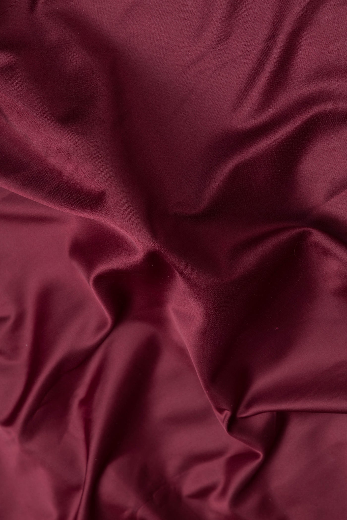 Close up of Maroon Dual Tone Blended Banarasi Silk Saree with Plain Body and Zari Border.  displaying folds