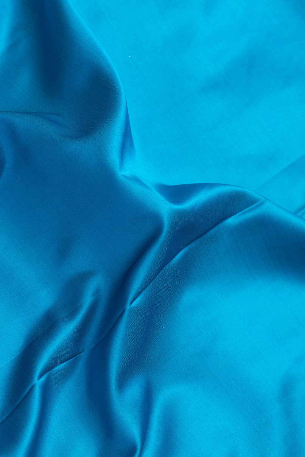 Close up of Sky Blue Dual Tone Banarasi Silk Saree with Plain Body and Zari Border.  displaying folds