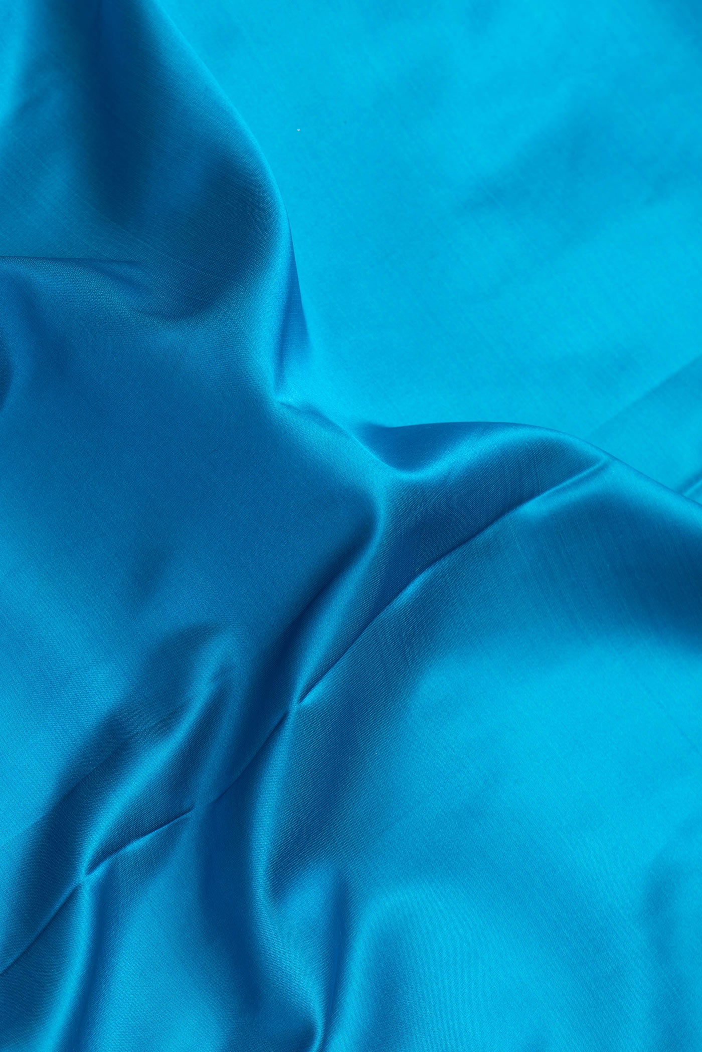 Close up of Sky Blue Dual Tone Banarasi Silk Saree with Plain Body and Zari Border.  displaying folds
