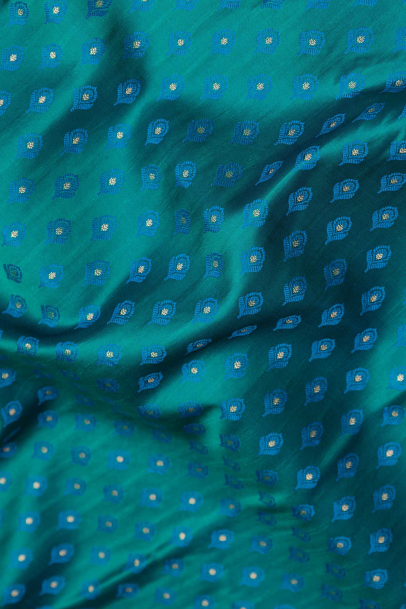 Close up of Peacock Blue Dual Tone Blended Banarasi Saree with Zari And Thread Butta on the body and Zari Border.  displaying folds