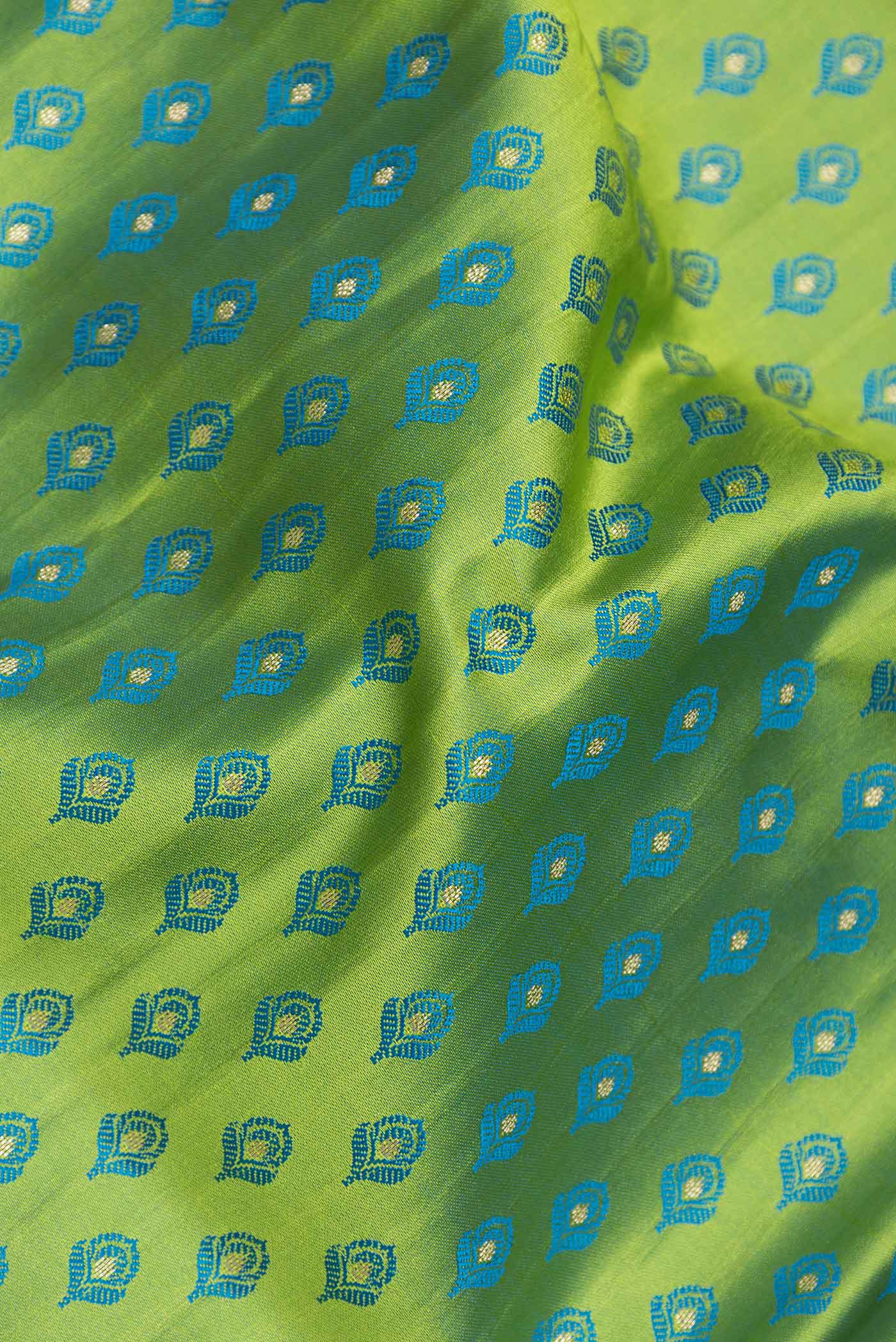Close up of Parrot Green Dual Tone Blended Banarasi Saree with Zari And Thread Butta on the body and Zari Border.  displaying folds