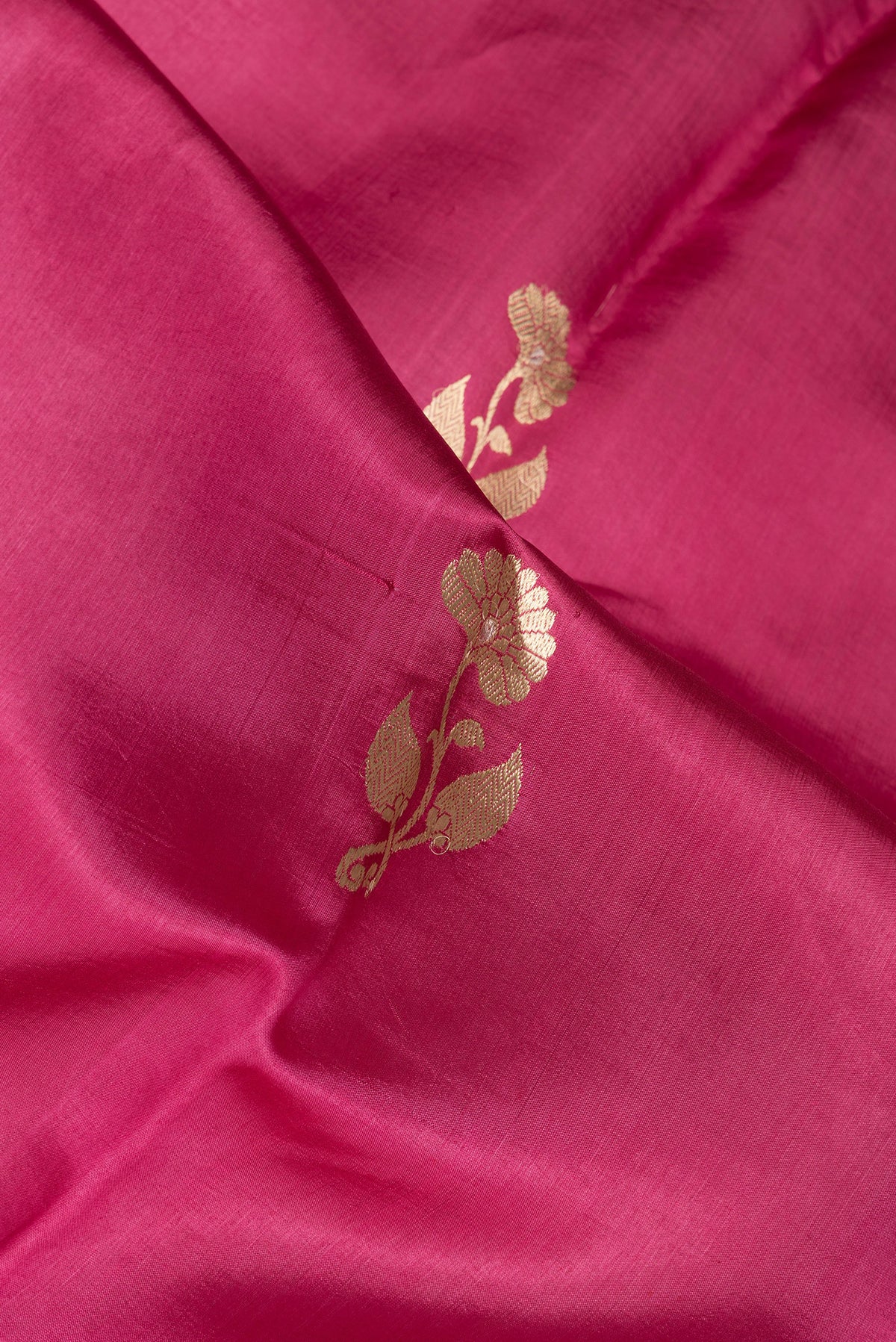 Close up of Pink Dual Tone Tussar Silk Saree with Zari Butta on the body and Zari Border.  displaying folds