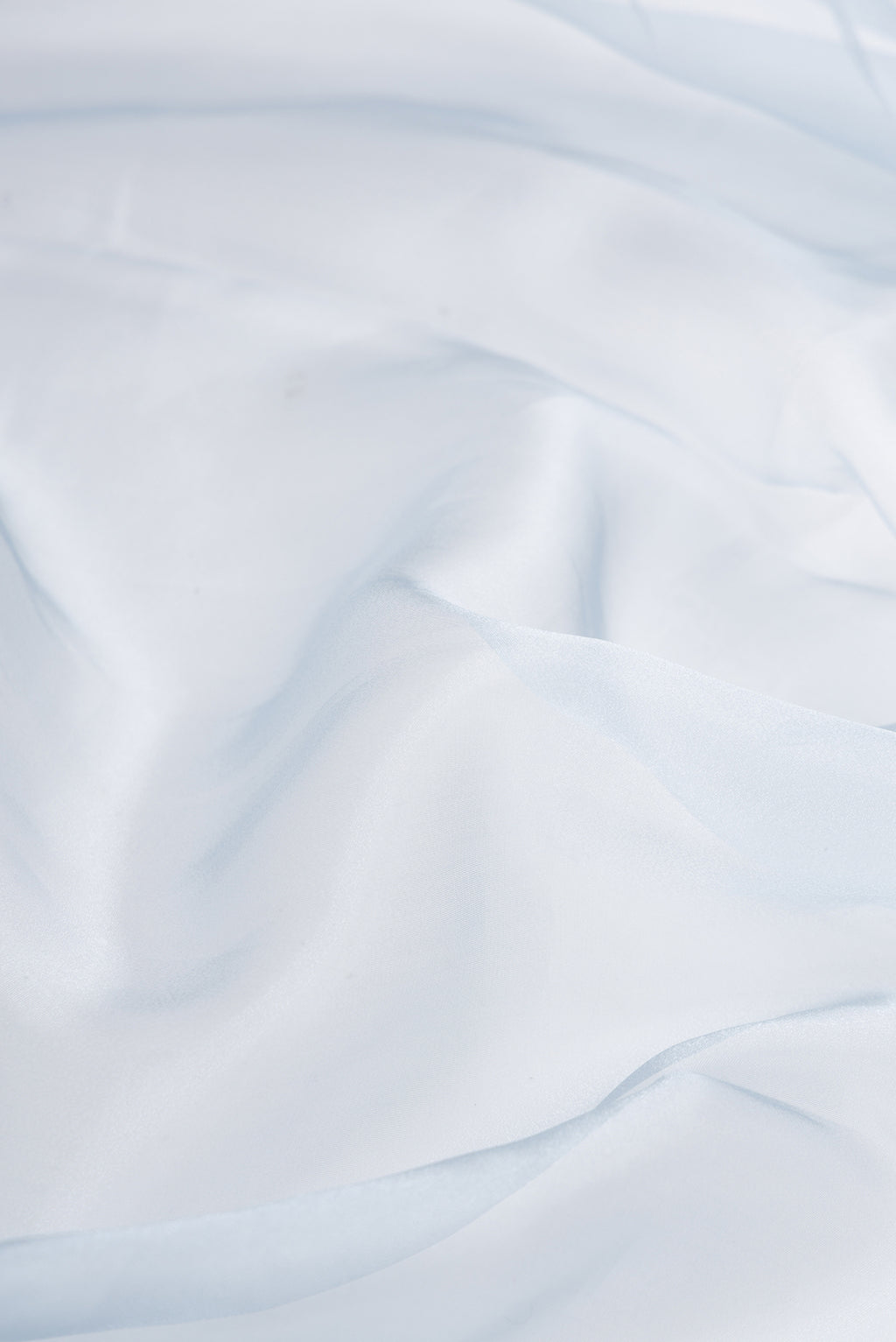Close up of Sky Blue Dual Tone Organza Silk Saree with Plain Body and Embroidery Border.  displaying folds