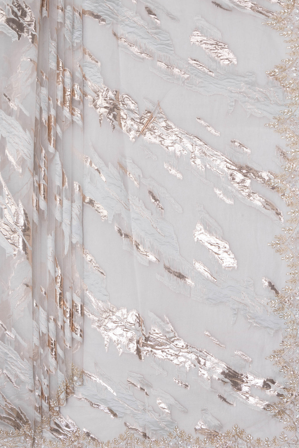 Pleats and pallu of Off White Organza Silk Saree with Zari Brocade on the body and Sequin Border. 