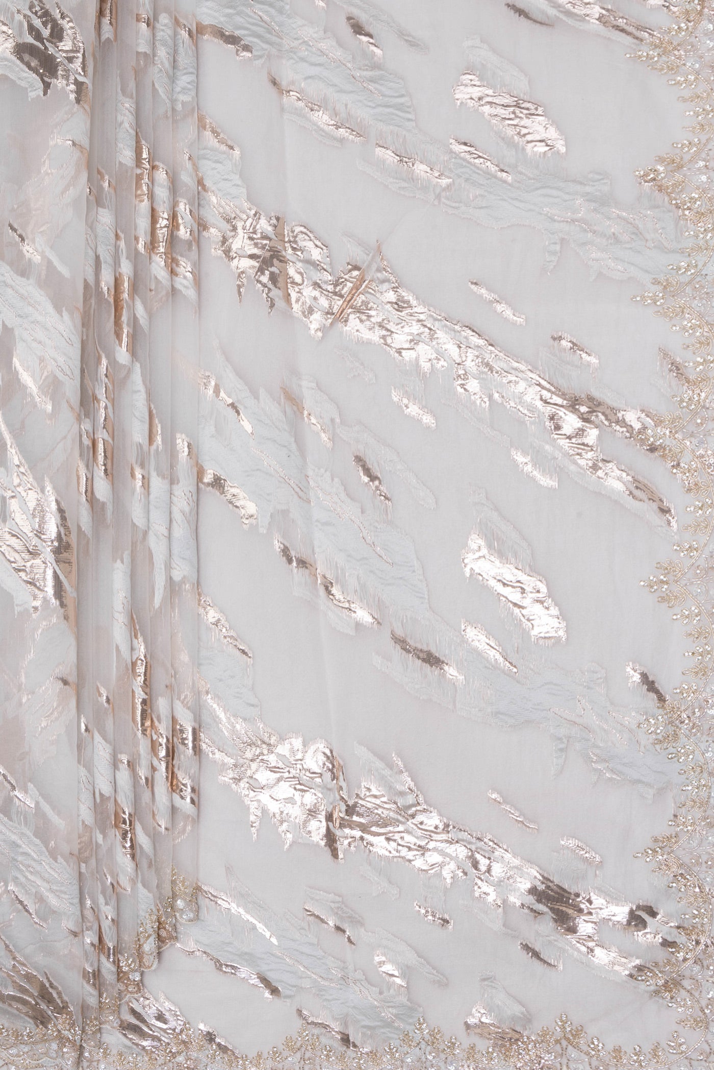 Pleats and pallu of Off White Organza Silk Saree with Zari Brocade on the body and Sequin Border. 