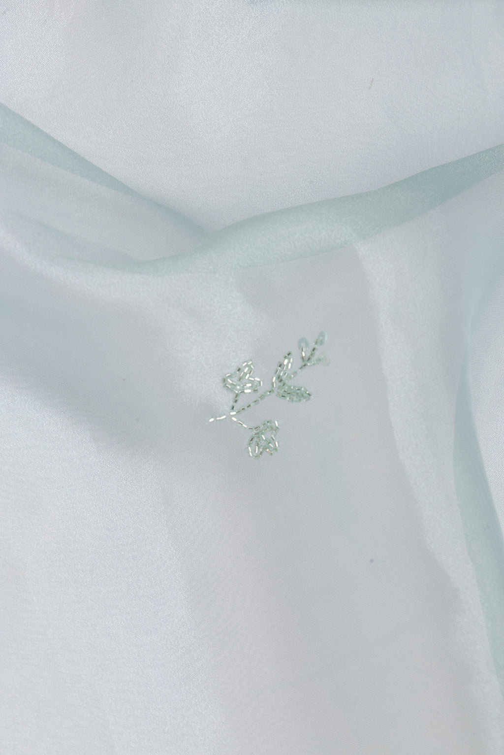 Close up of Pure Silk Light Blue Organza Saree with Embroidery on the body and Embroidery Border.  displaying folds