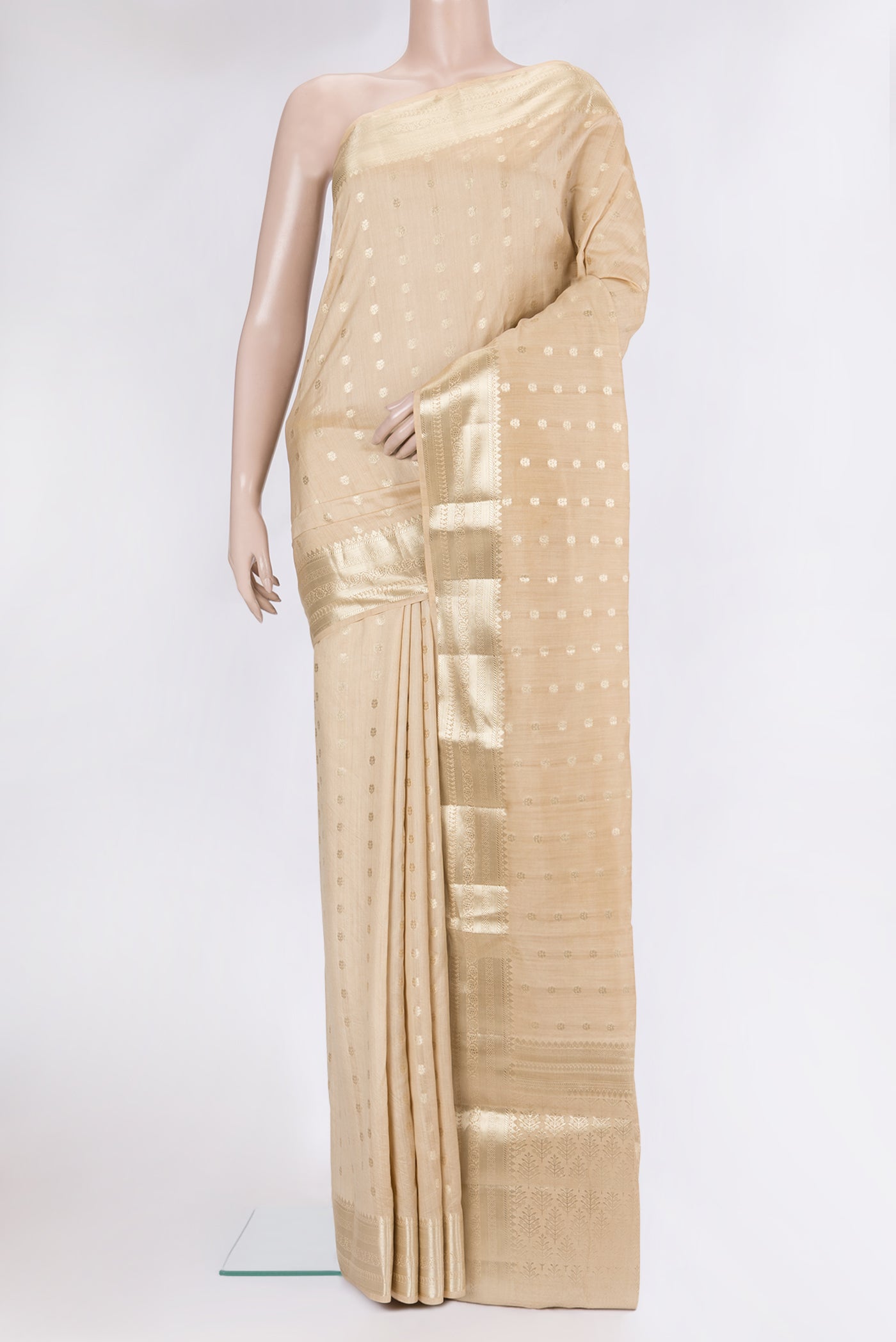 Beige Tussar Silk Saree with Zari Butta on the body and Zari Border.  displayed on a mannequin