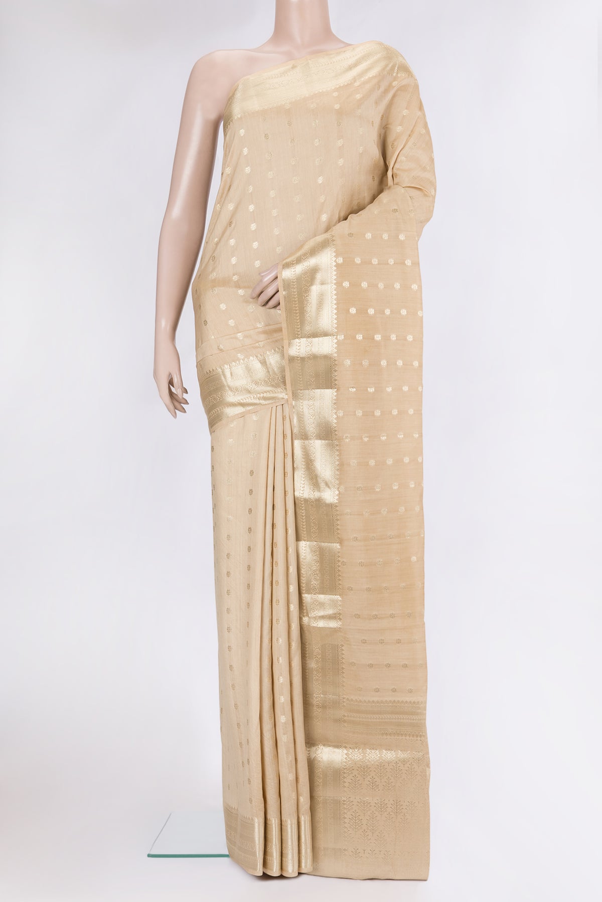 Beige Tussar Silk Saree with Zari Butta on the body and Zari Border.  displayed on a mannequin