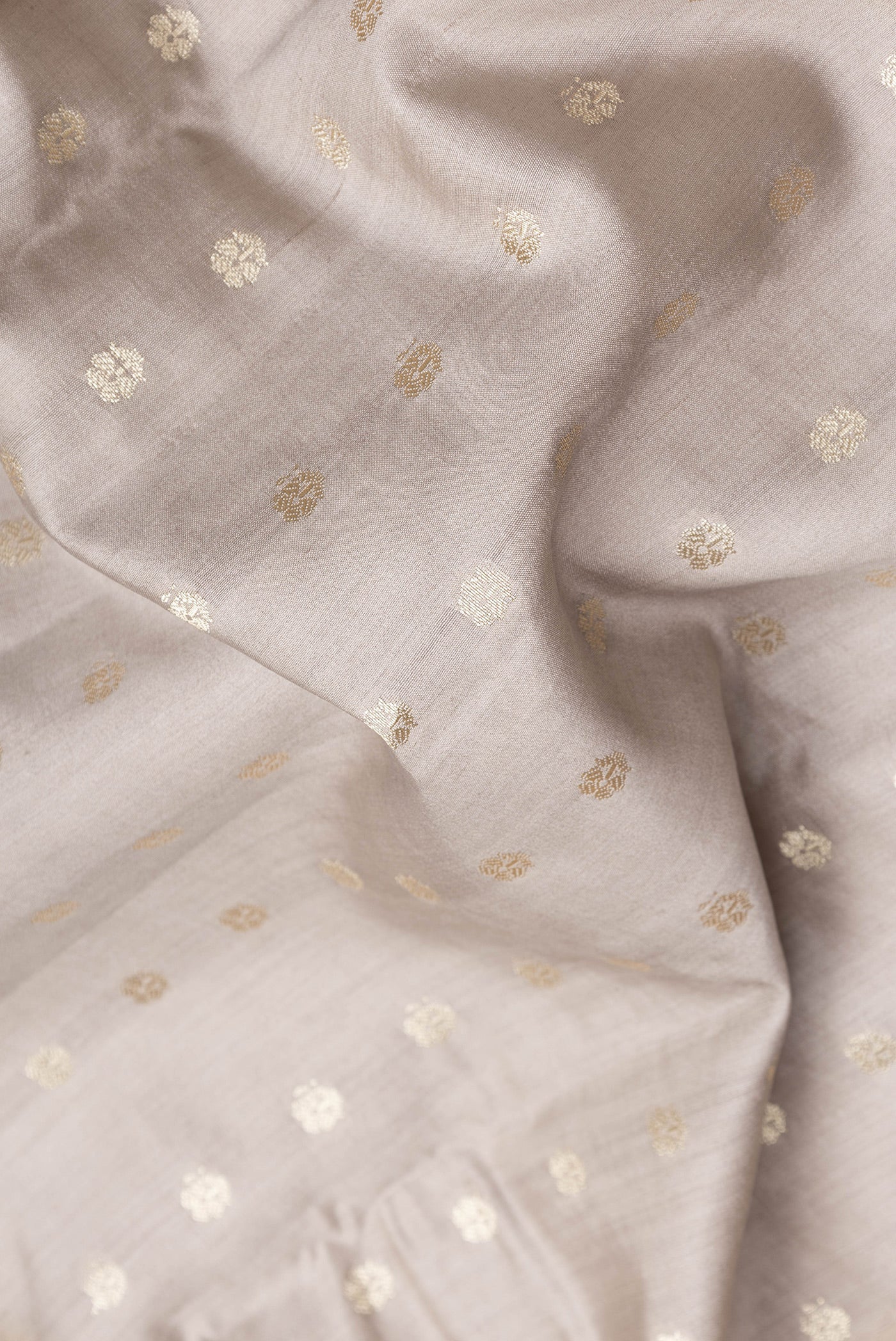 Close up of Grey Dual Tone Tussar Silk Saree with Zari Butta on the body and Zari Border.  displaying folds