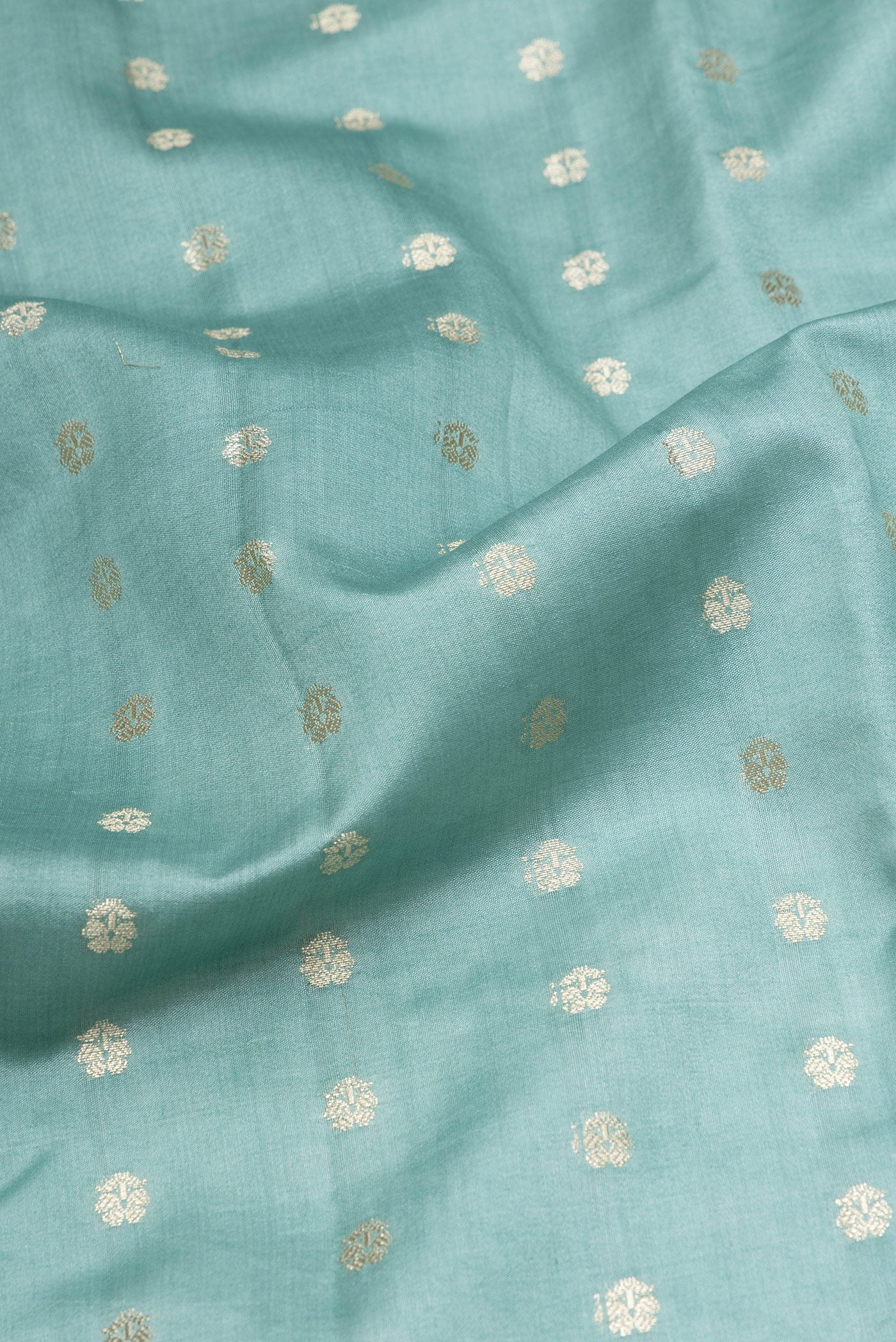 Close up of Light Blue Tussar Silk Saree with Zari Butta on the body and Zari Border.  displaying folds