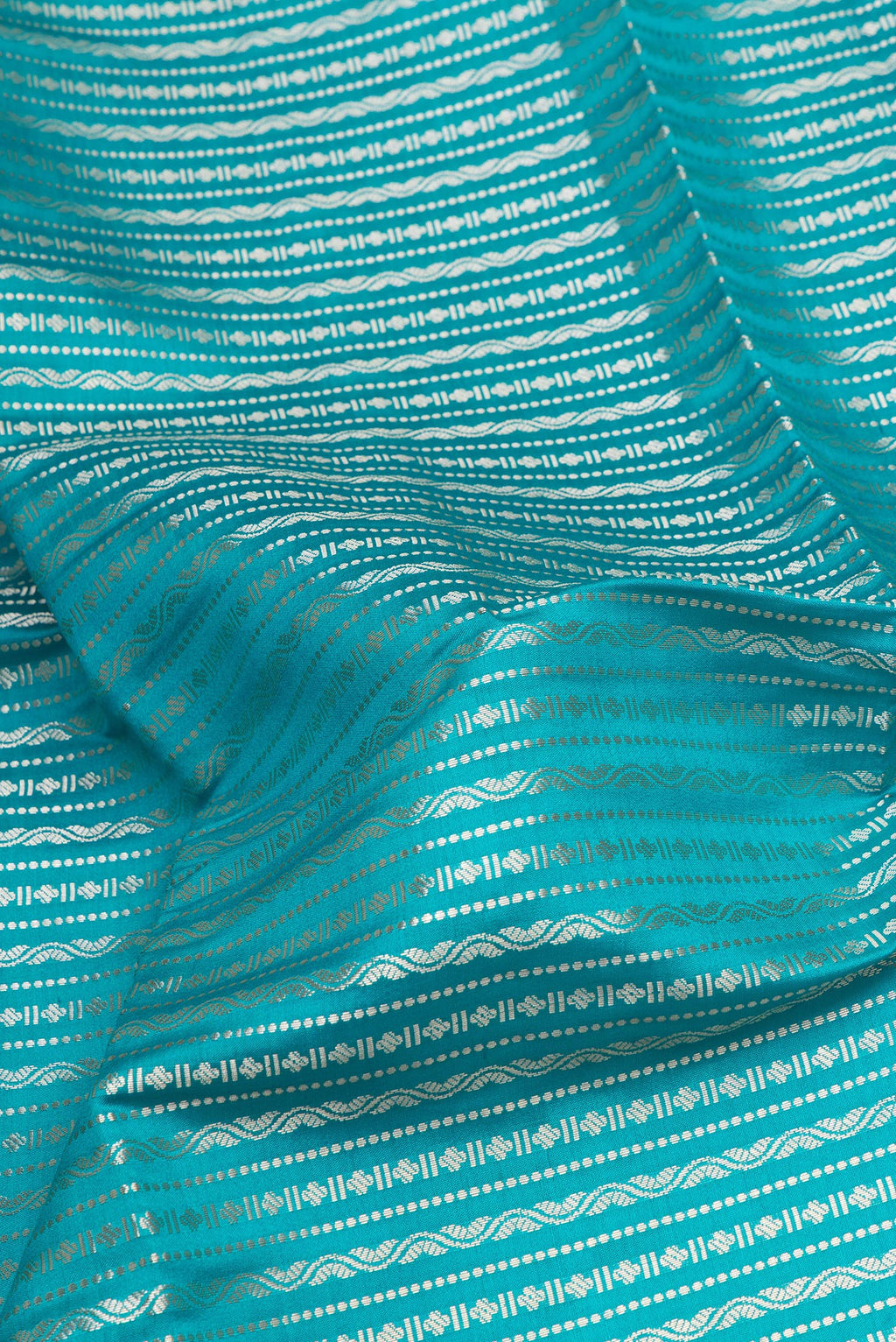 Close up of Peacock Blue Tussar Silk Saree with Zari Brocade on the body and Zari Border.  displaying folds
