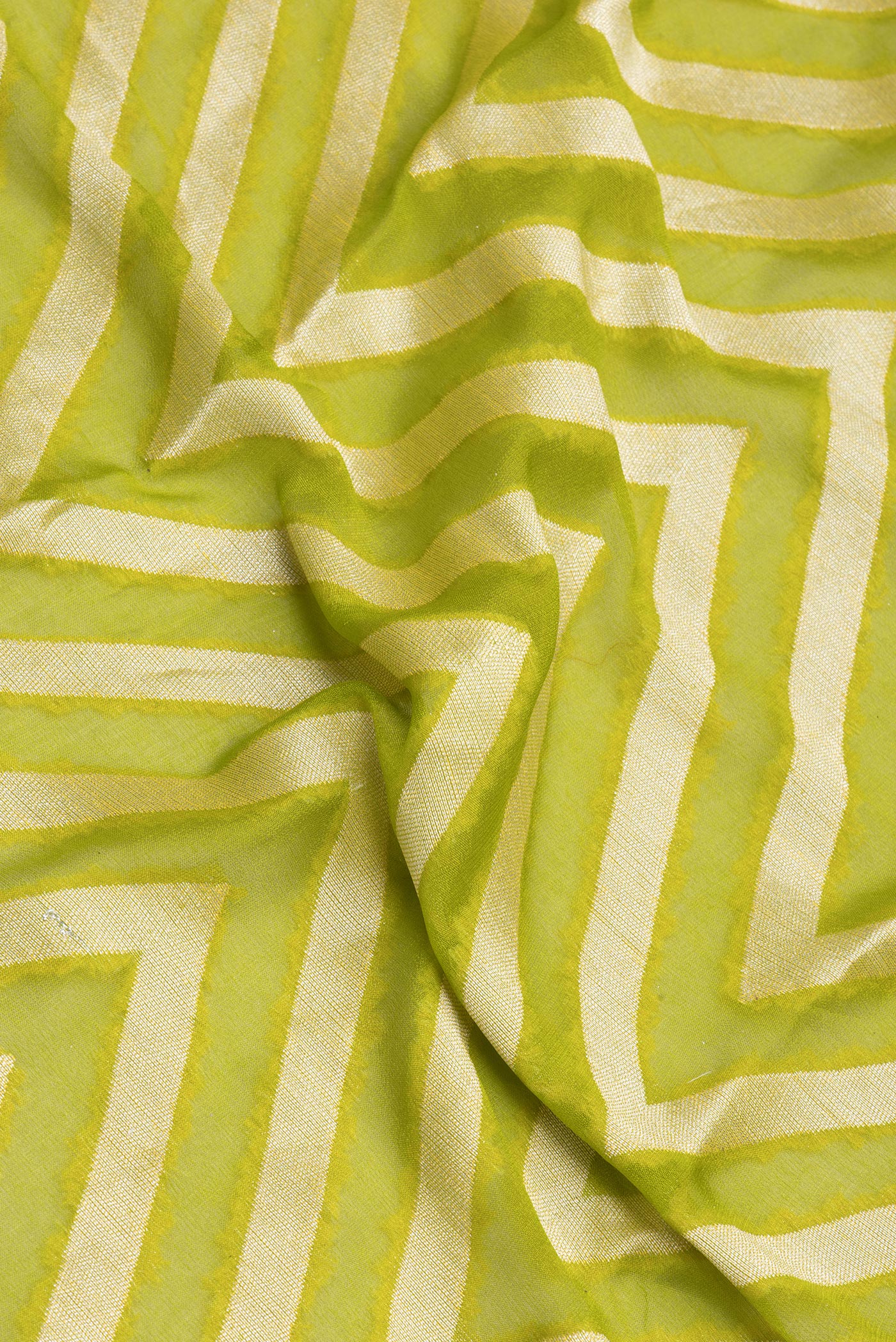 Close up of Parrot Green Banarasi Georgette Saree with Zig Zag design on the body and Zari Border.  displaying folds