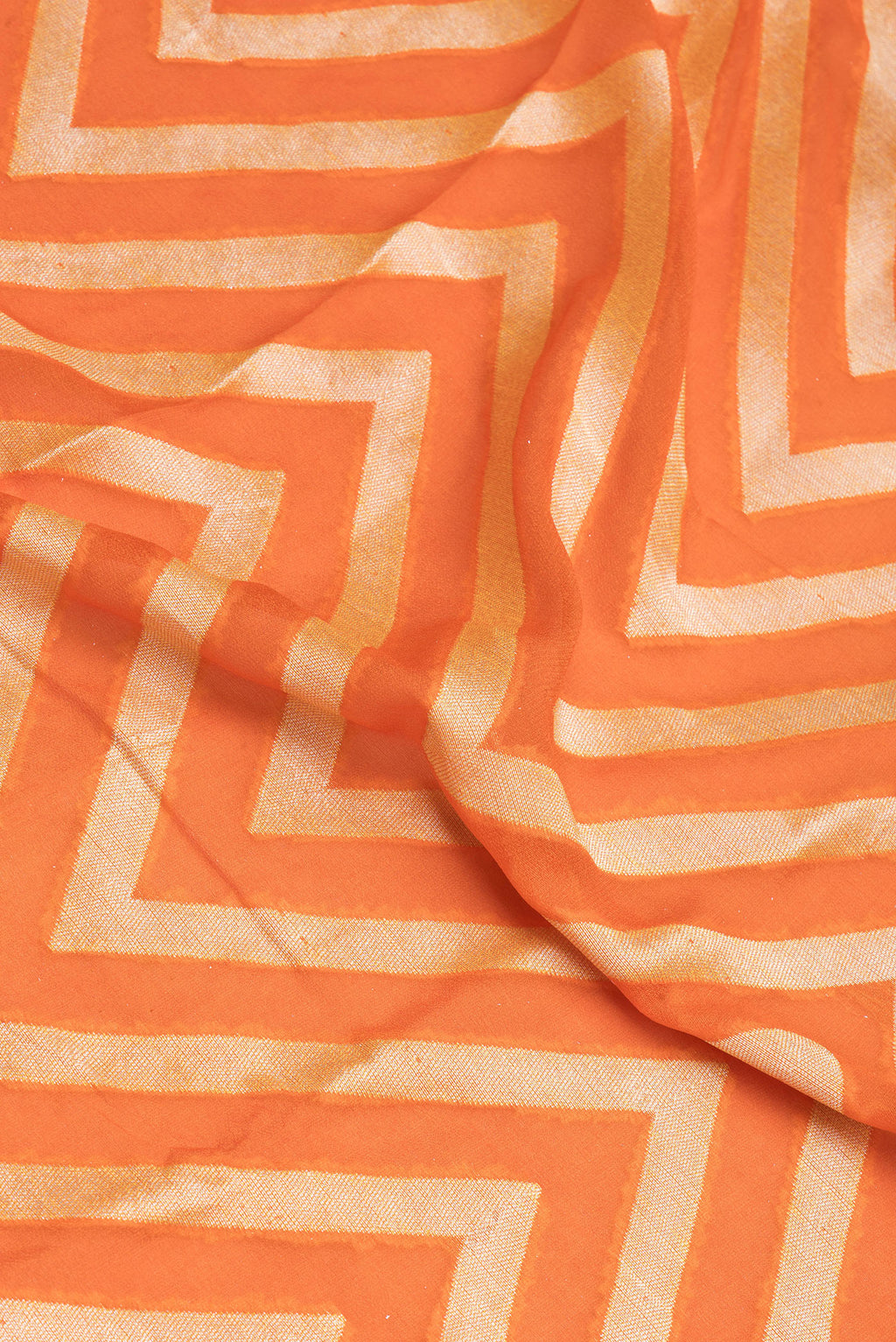 Close up of Orange Banarasi Georgette Saree with Zig Zag design on the body and Fancy Border.  displaying folds