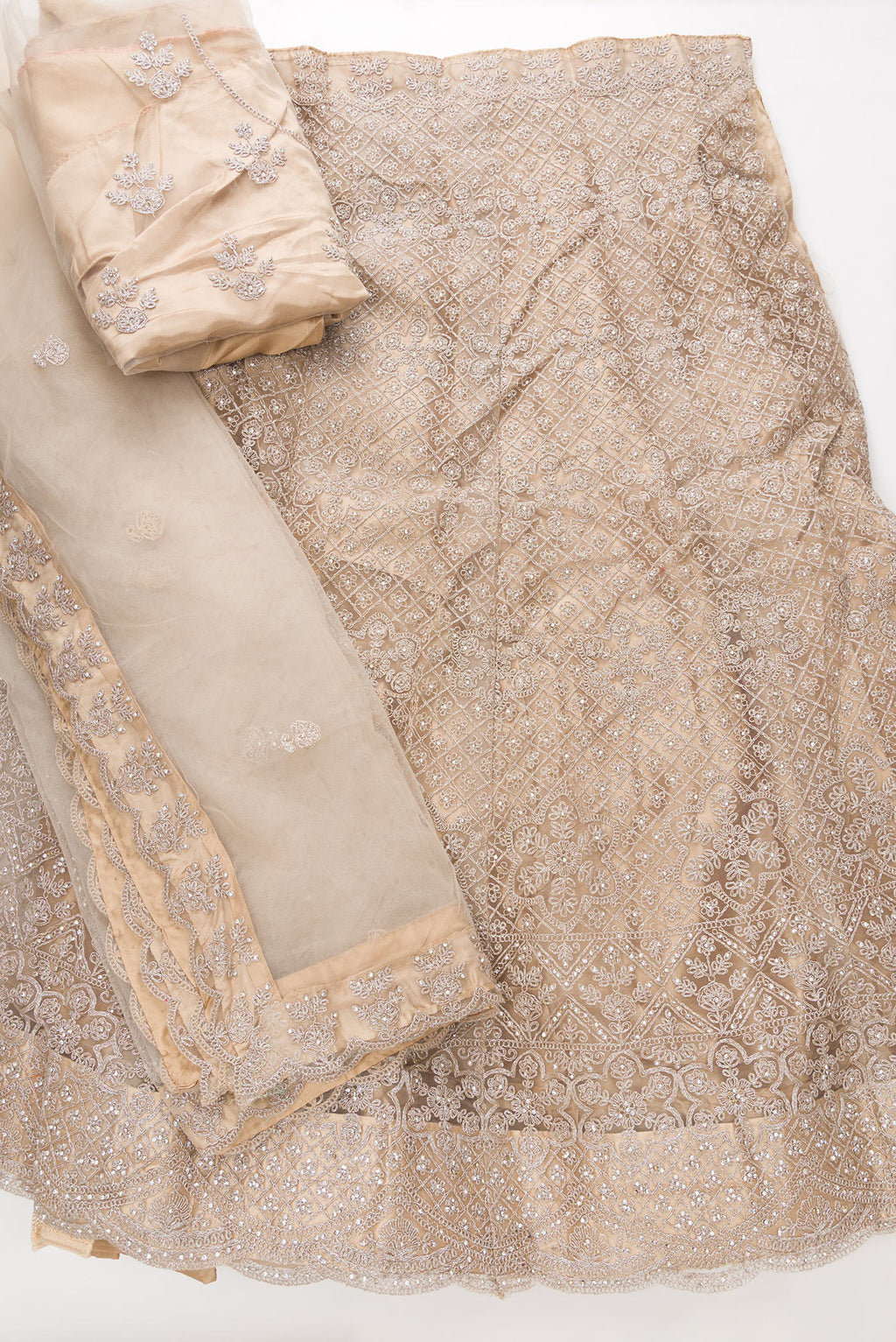 Flat lay of Caramel Raw Silk Womens Lehenga set featuring Embroidered Choli paired with Caramel Embroidered Skirt with Embroidered Border and a Embroidered dupatta in Caramel