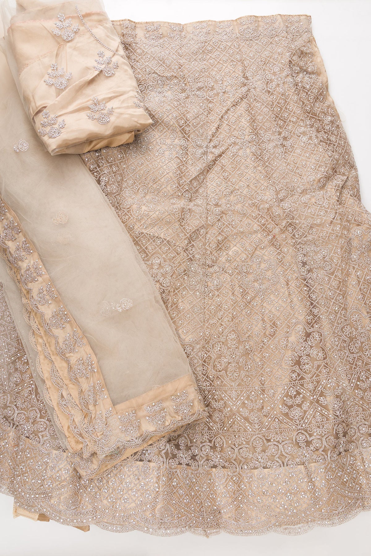Flat lay of Caramel Raw Silk Womens Lehenga set featuring Embroidered Choli paired with Caramel Embroidered Skirt with Embroidered Border and a Embroidered dupatta in Caramel