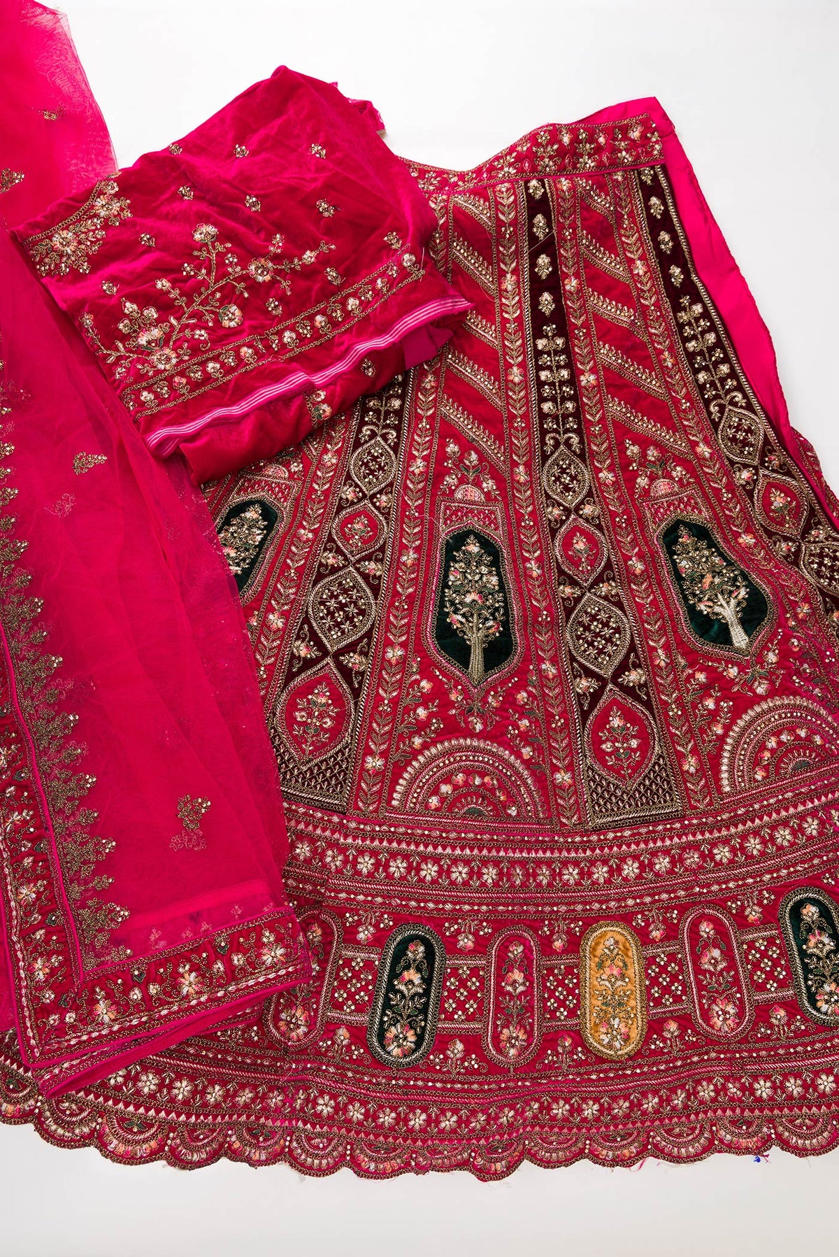 Flat lay of Dark Pink Raw Silk Womens Lehenga set featuring Embroidered Choli paired with Dark Pink Embroidered Skirt with Embroidered Border and a Embroidered dupatta in Dark Pink