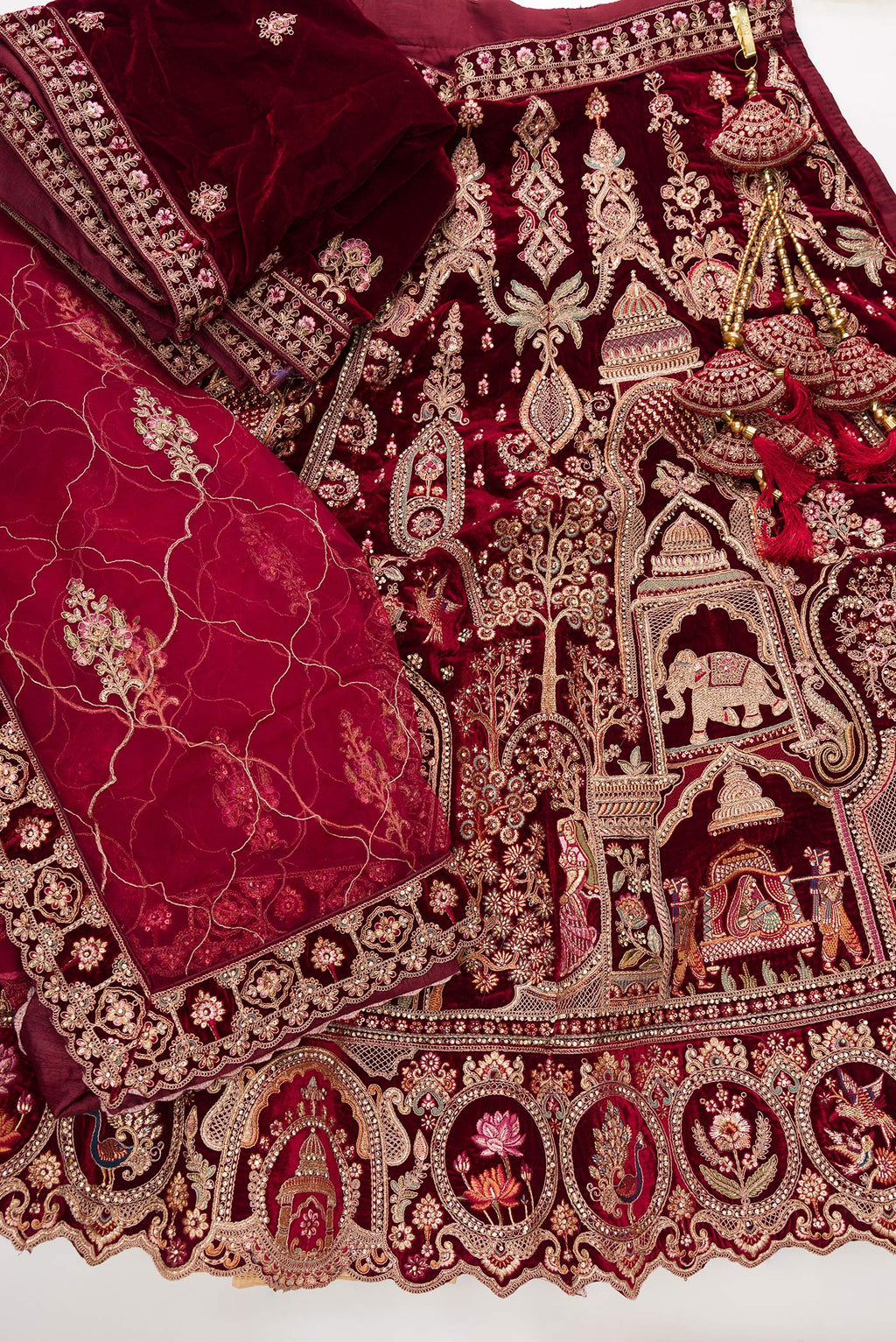 Flat lay of Maroon Banarasi Silk Womens Lehenga set featuring Embroidered Choli paired with Maroon Embroidered Skirt with Embroidered Border and a Embroidered dupatta in Maroon