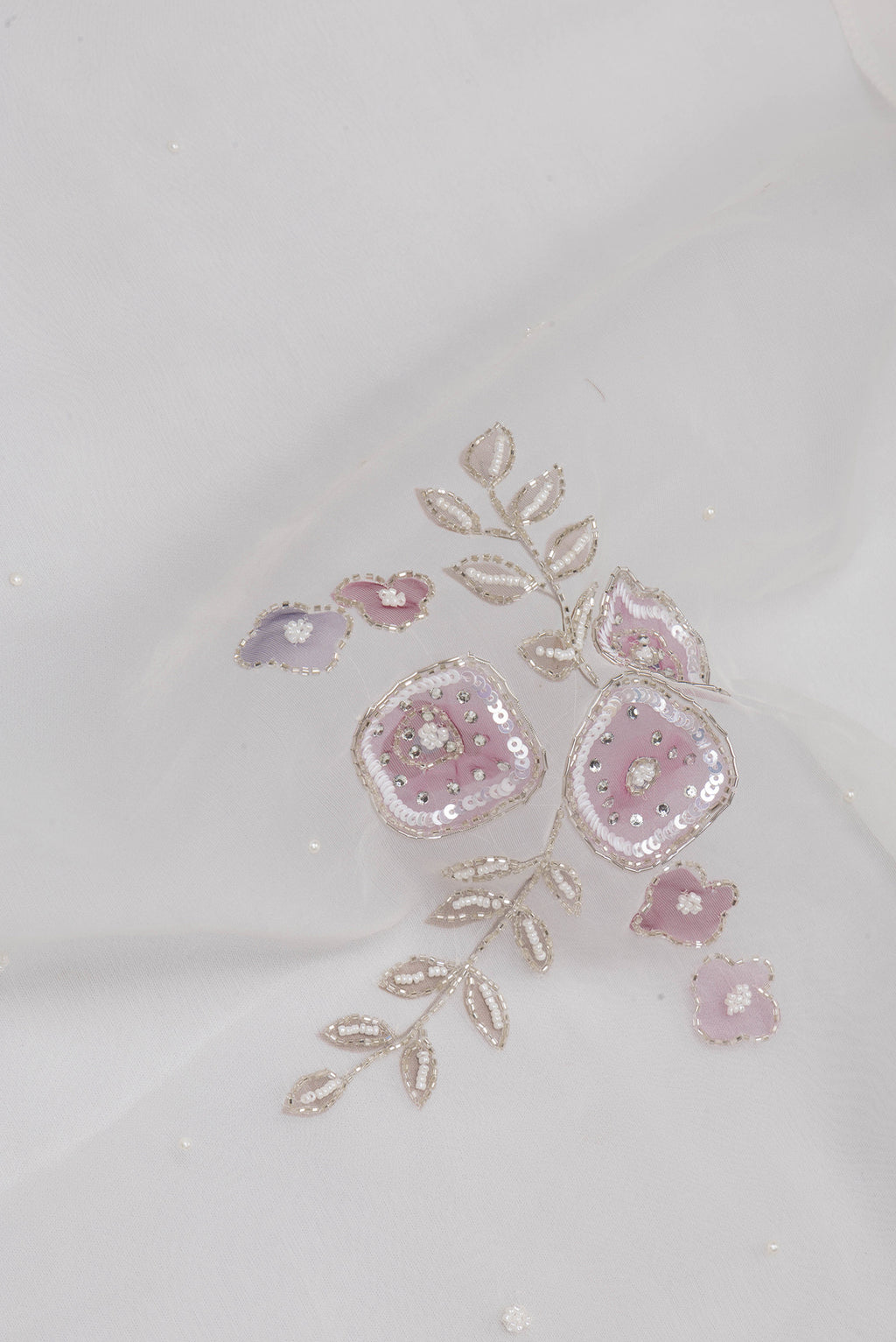 Close up of Off White Organza Saree with Embroidery on the body and Embroidery Border.  displaying folds