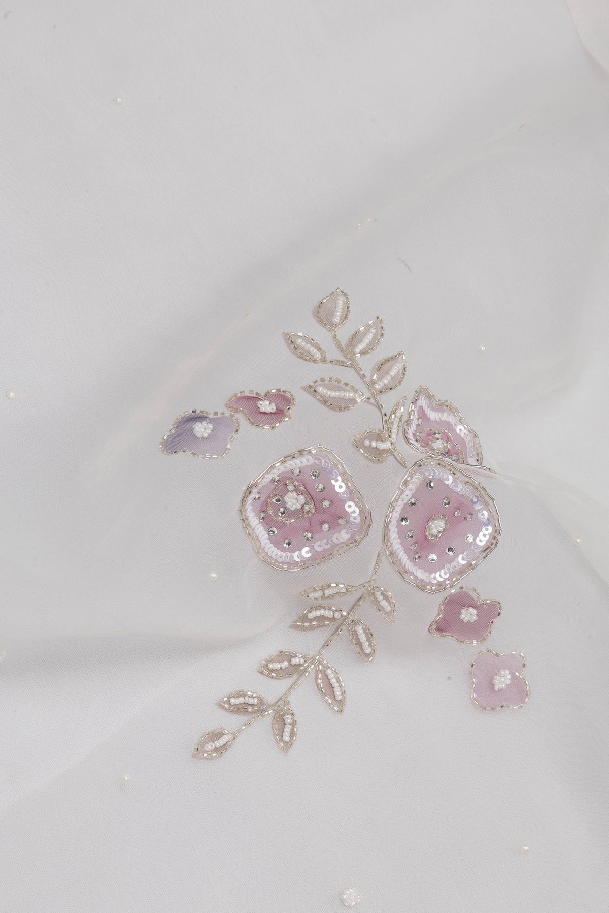 Close up of Off White Organza Saree with Embroidery on the body and Embroidery Border.  displaying folds