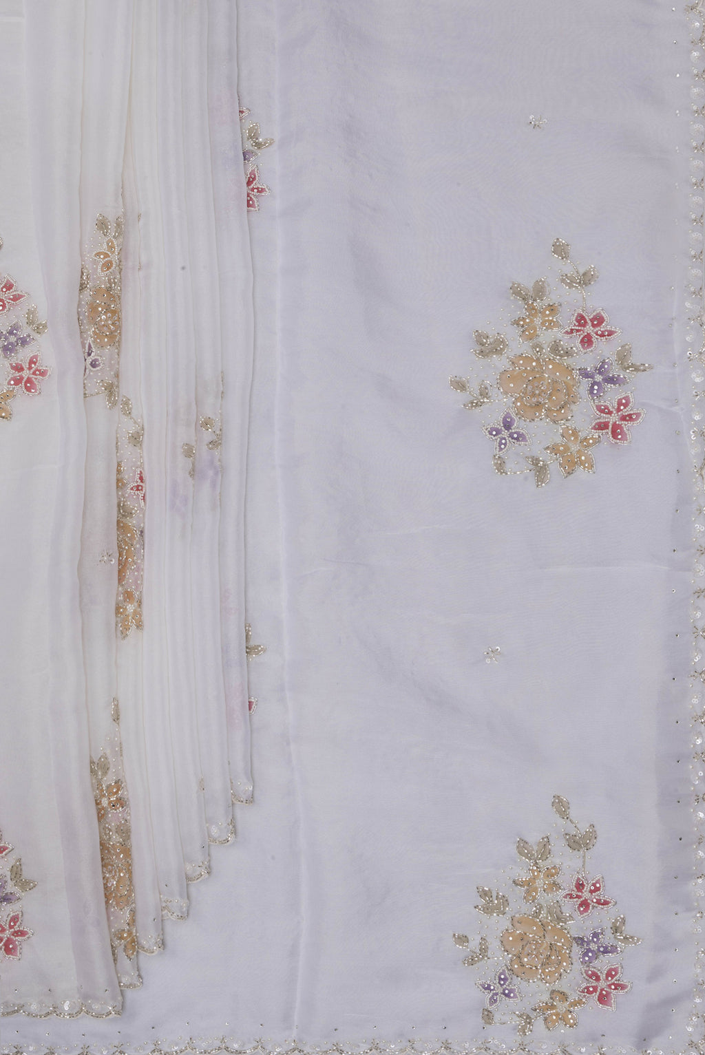 Pleats and pallu of Off White Organza Saree with Embroidery on the body and Embroidery Border. 