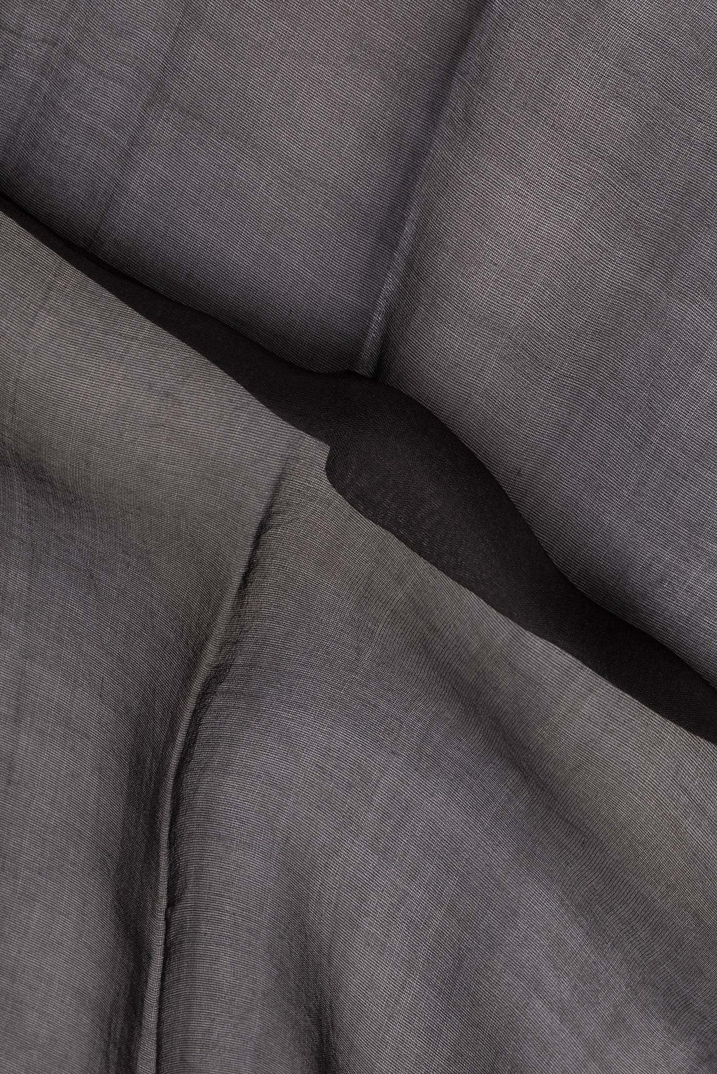 Close up of Black Tussar Saree with Plain Body and Zari Border.  displaying folds