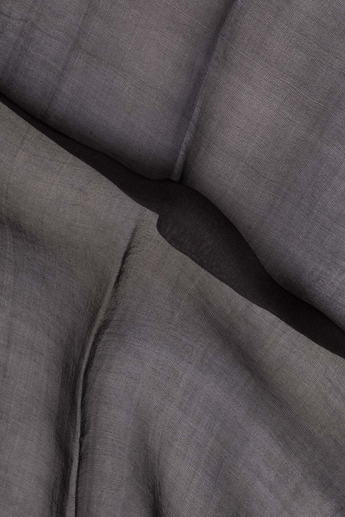 Close up of Black Tussar Saree with Plain Body and Zari Border.  displaying folds