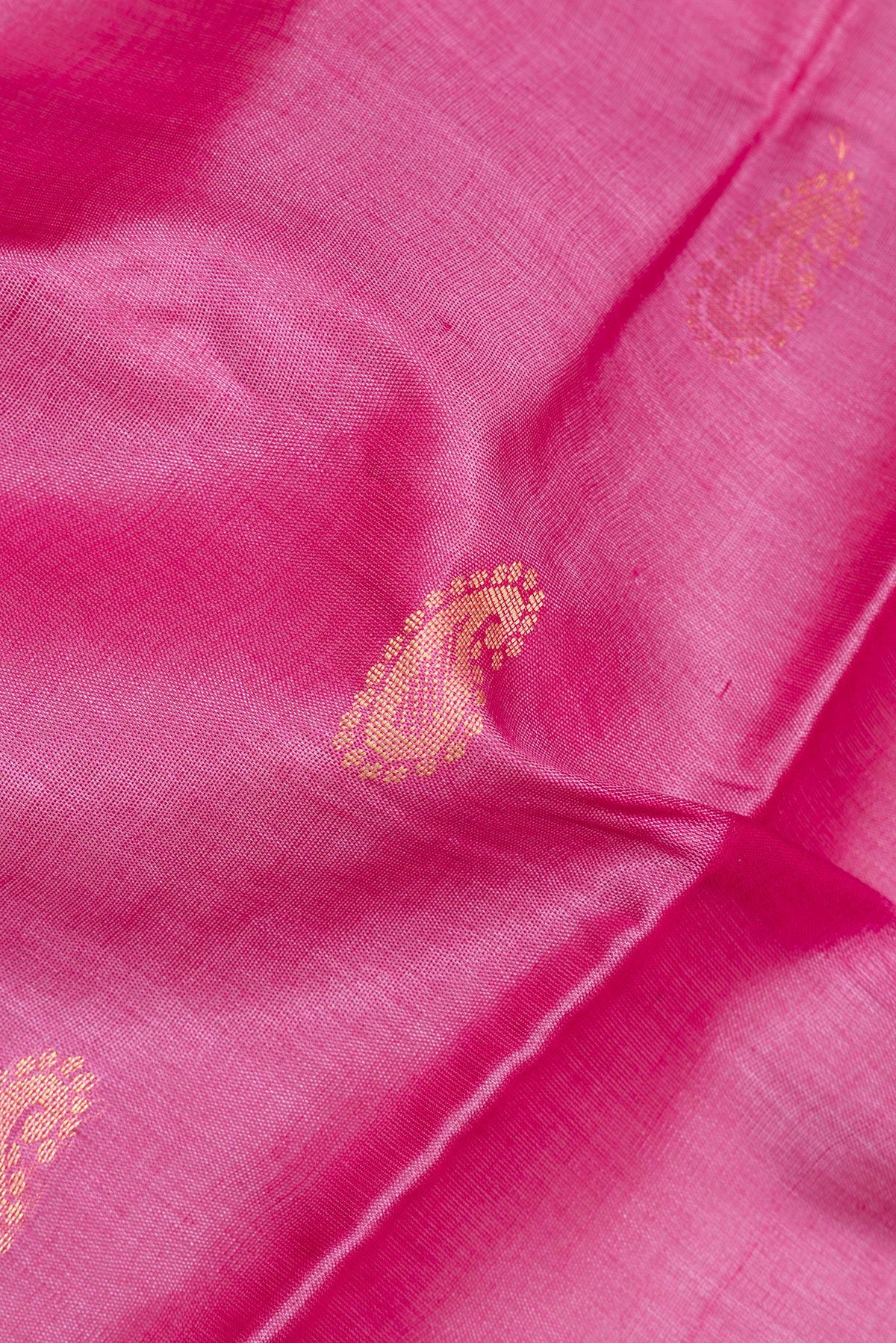 Close up of Pink Tussar Saree with Zari And Thread Butta on the body and Plain Border.  displaying folds