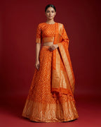 Orange Banarasi Silk Womens Lehenga set featuring Embroidered Choli paired with Orange Zari Brocade Skirt with Zari Border and a Embroidered dupatta in Orange