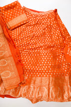Flat lay of Orange Banarasi Silk Womens Lehenga set featuring Embroidered Choli paired with Orange Zari Brocade Skirt with Zari Border and a Embroidered dupatta in Orange