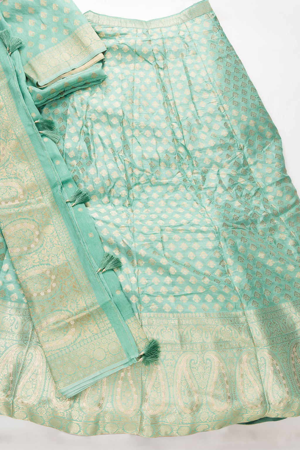 Flat lay of Light Green Banarasi Silk Womens Lehenga set featuring Zari Brocade Choli paired with Light Green Zari Brocade Skirt with Zari Border and a Zari Butta dupatta in Light Green