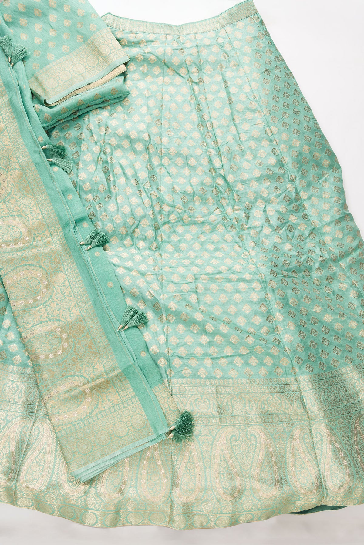Flat lay of Light Green Banarasi Silk Womens Lehenga set featuring Zari Brocade Choli paired with Light Green Zari Brocade Skirt with Zari Border and a Zari Butta dupatta in Light Green