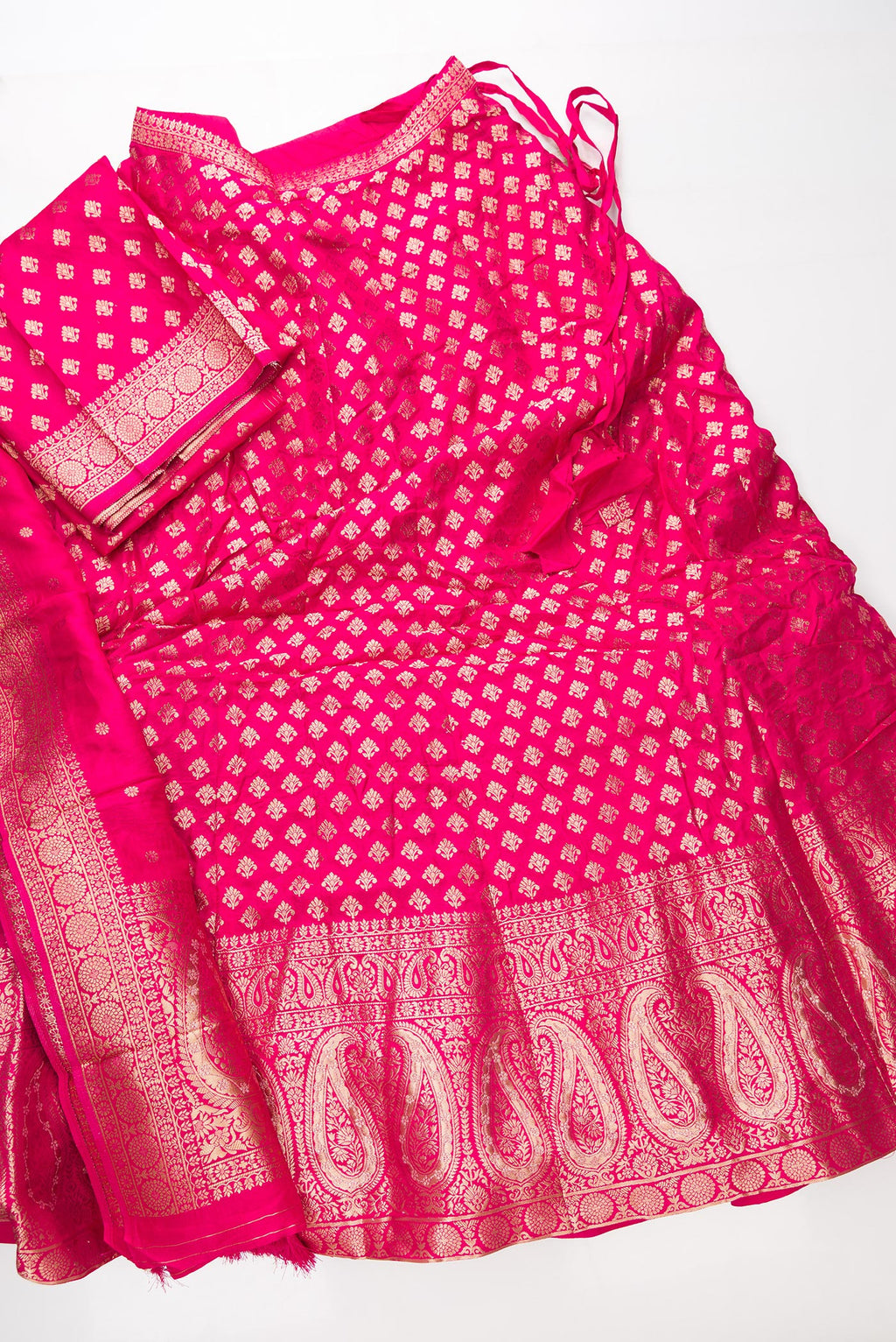 Flat lay of Dark Pink Banarasi Silk Womens Lehenga set featuring Zari Brocade Choli paired with Dark Pink Zari Brocade Skirt with Zari Border and a Zari Butta dupatta in Dark Pink