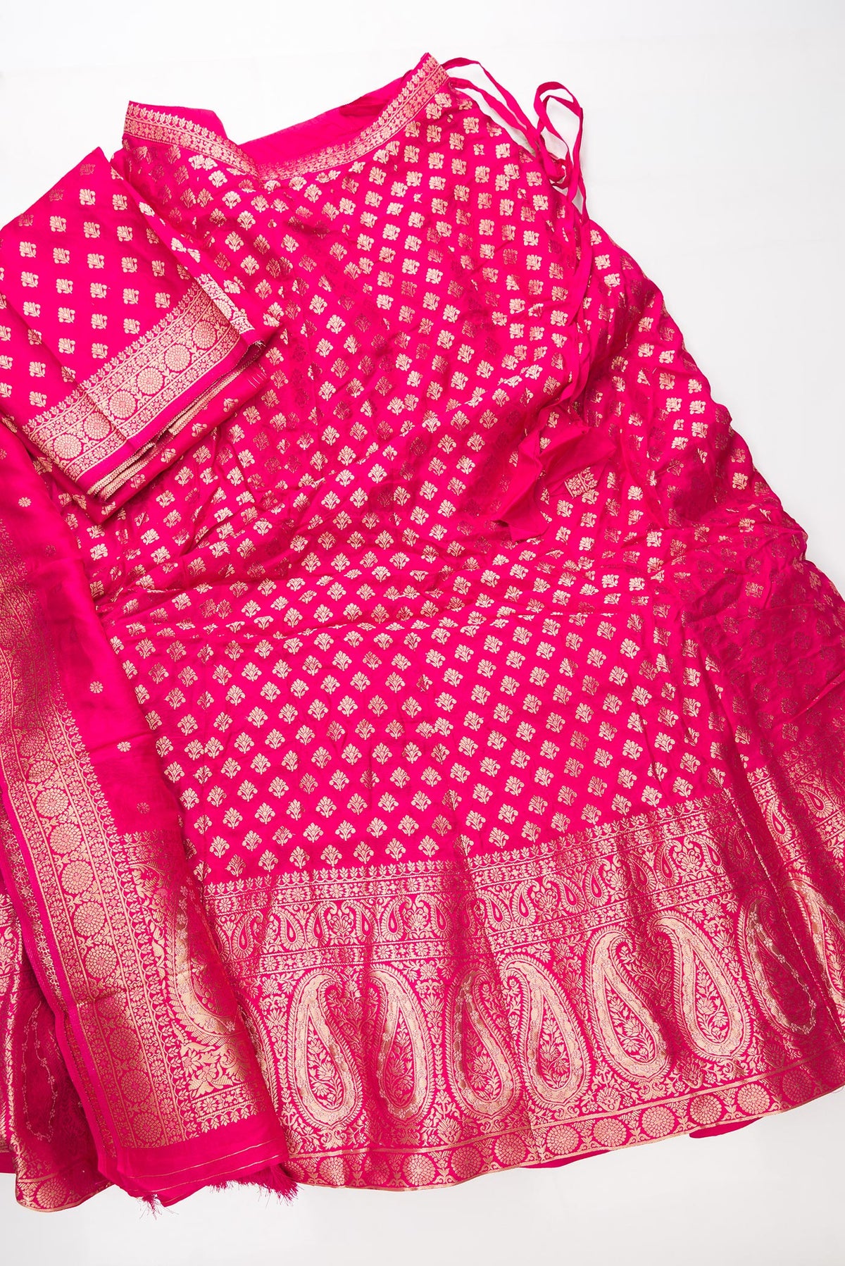 Flat lay of Dark Pink Banarasi Silk Womens Lehenga set featuring Zari Brocade Choli paired with Dark Pink Zari Brocade Skirt with Zari Border and a Zari Butta dupatta in Dark Pink
