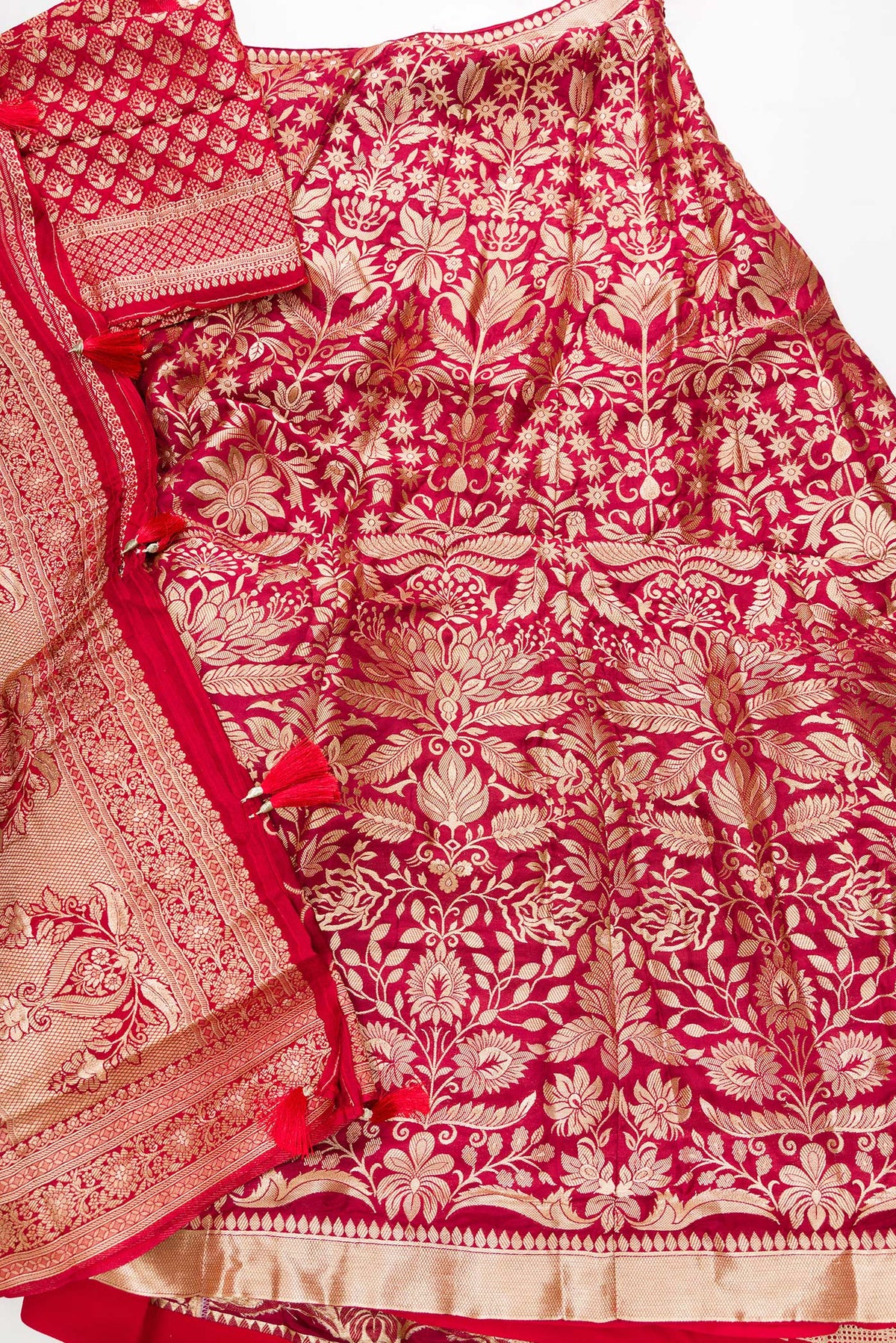 Flat lay of Imperial Red Banarasi Silk Womens Lehenga set featuring Zari Brocade Choli paired with Imperial Red Zari Brocade Skirt with Zari Border and a Zari Butta dupatta in Imperial Red
