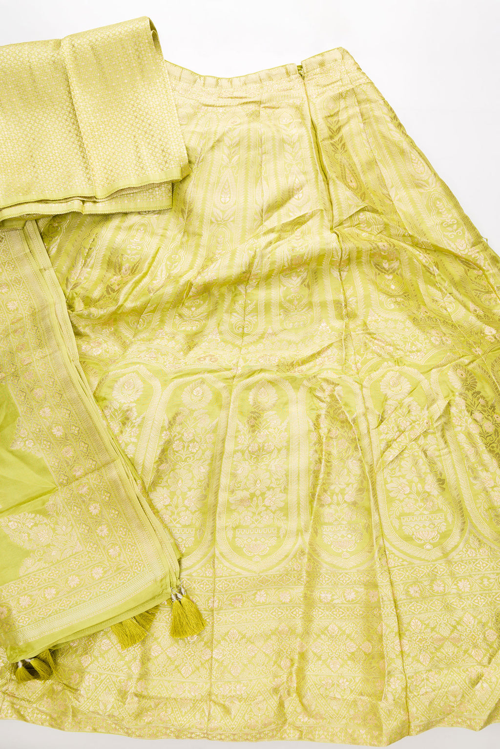 Flat lay of Light Green Banarasi Silk Womens Lehenga set featuring Zari Brocade Choli paired with Light Green Zari Brocade Skirt with Zari Border and a Zari Butta dupatta in Light Green