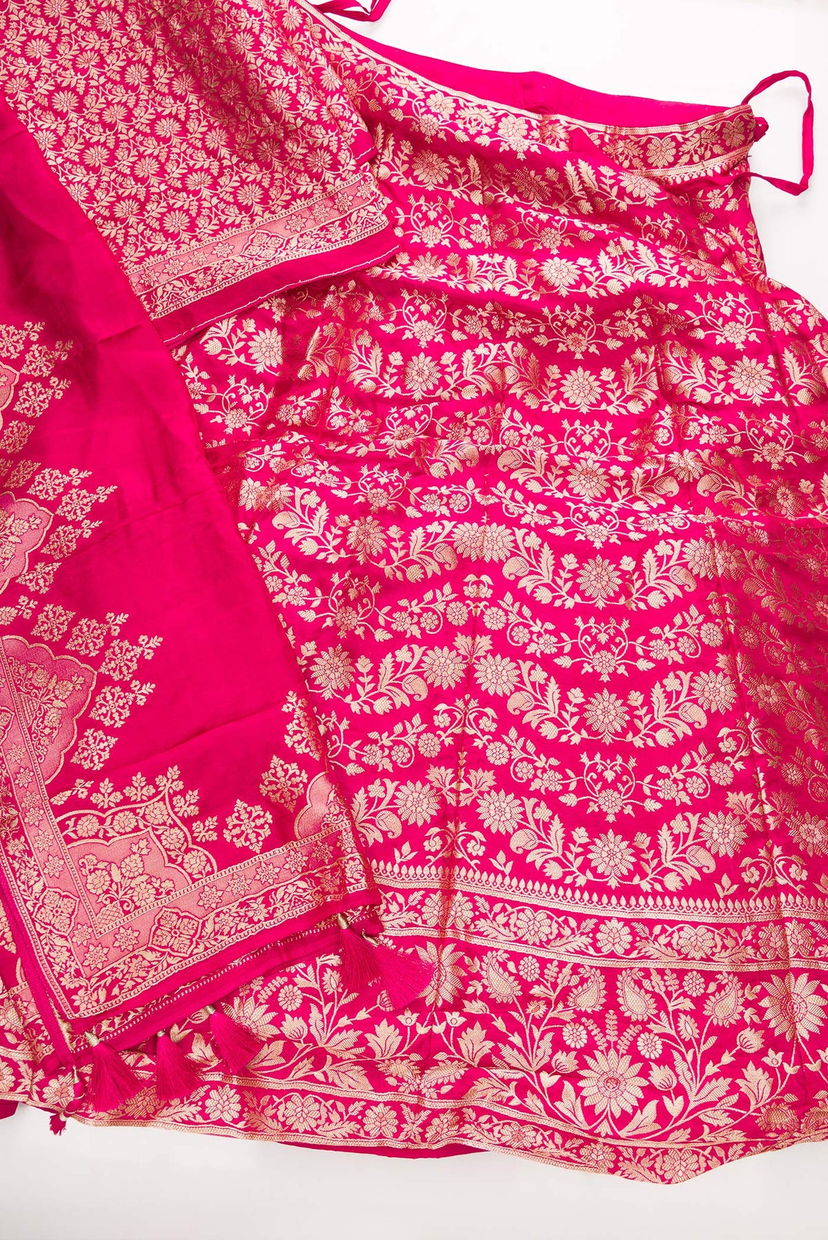 Flat lay of Dark Pink Banarasi Silk Womens Lehenga set featuring Zari Brocade Choli paired with Dark Pink Zari Brocade Skirt with Zari Border and a Zari Butta dupatta in Dark Pink