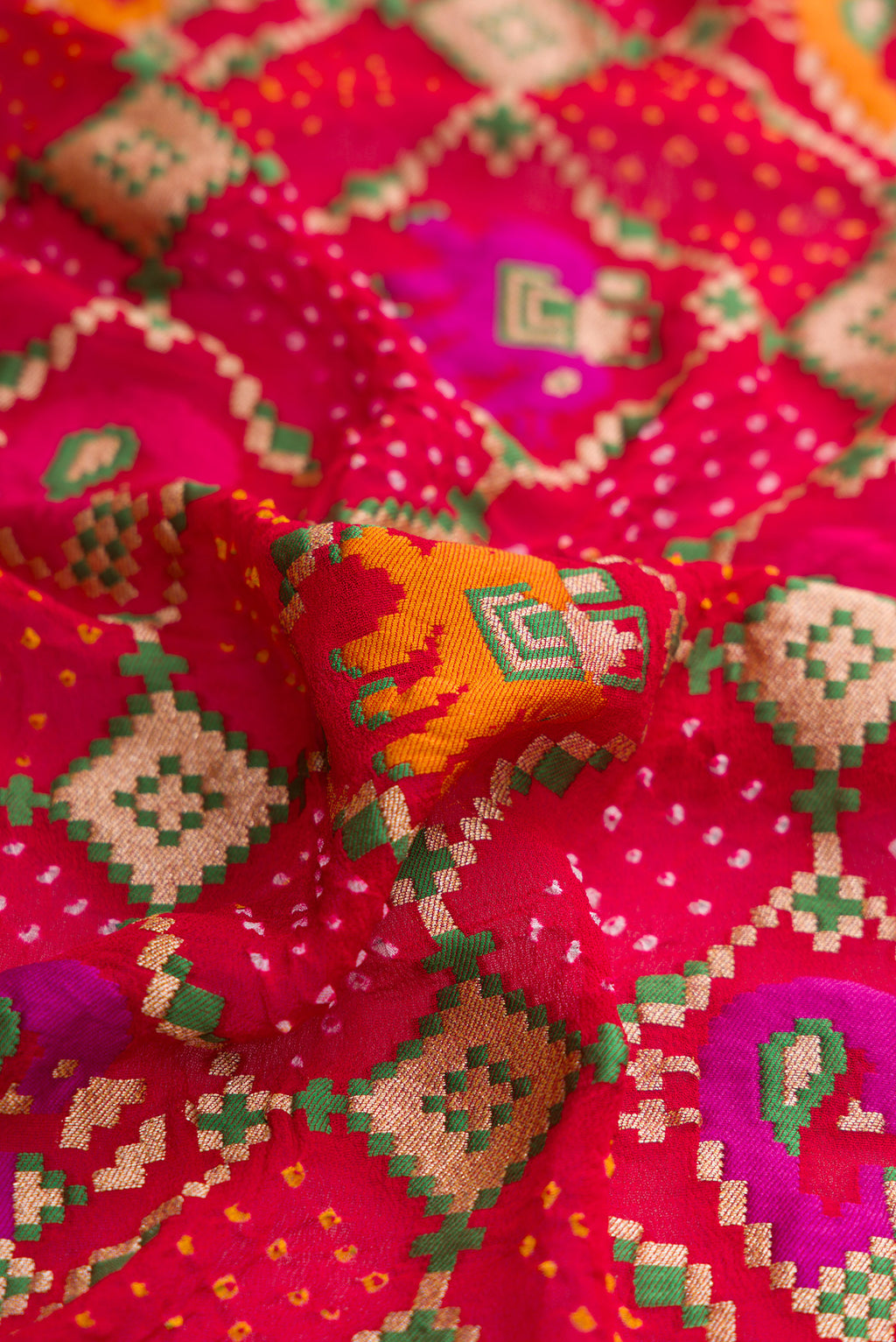 Close up of Red Dual Tone Banarasi Georgette Saree with Bandhani Print on the body and Fancy Border.  displaying folds
