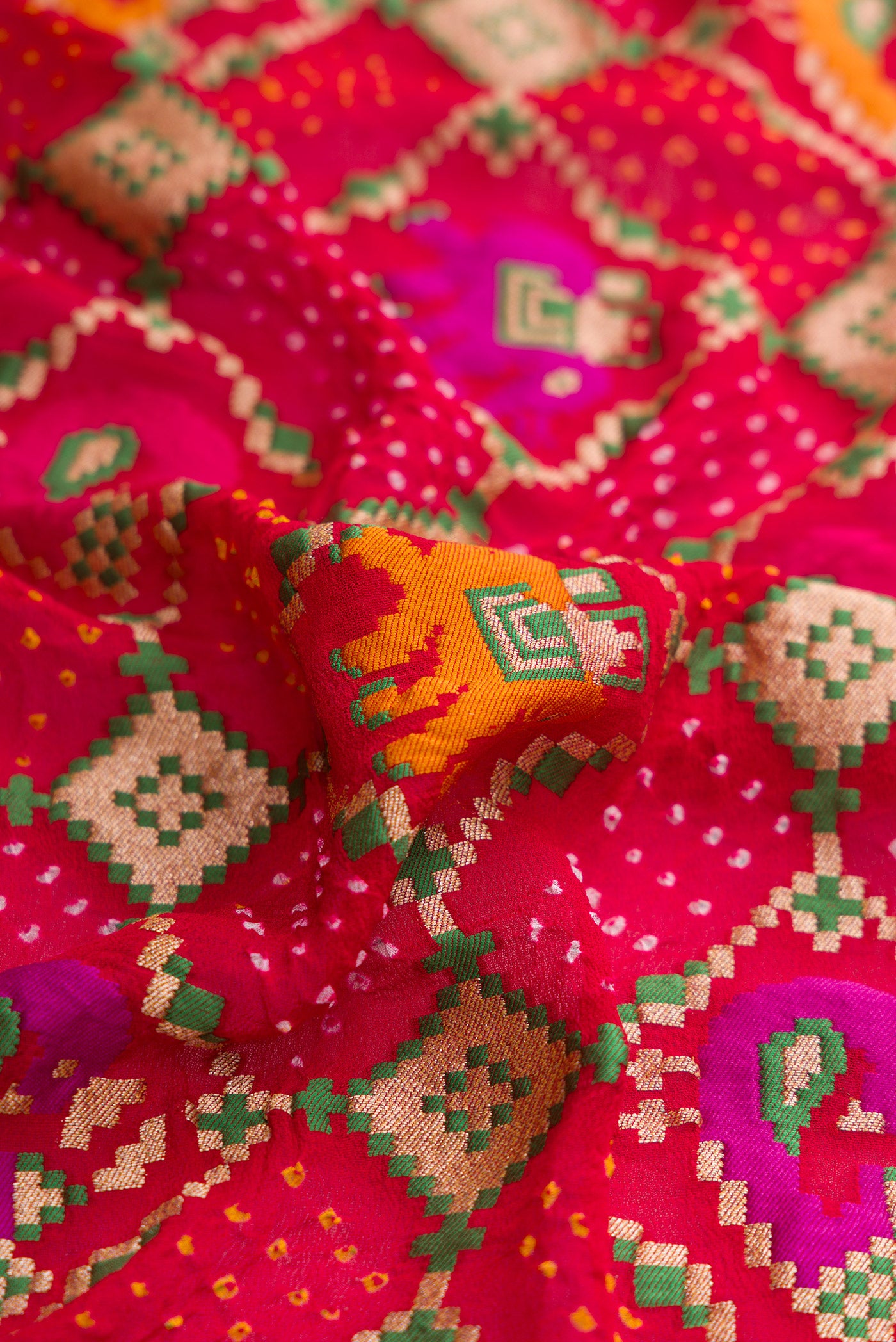 Close up of Red Dual Tone Banarasi Georgette Saree with Bandhani Print on the body and Fancy Border.  displaying folds