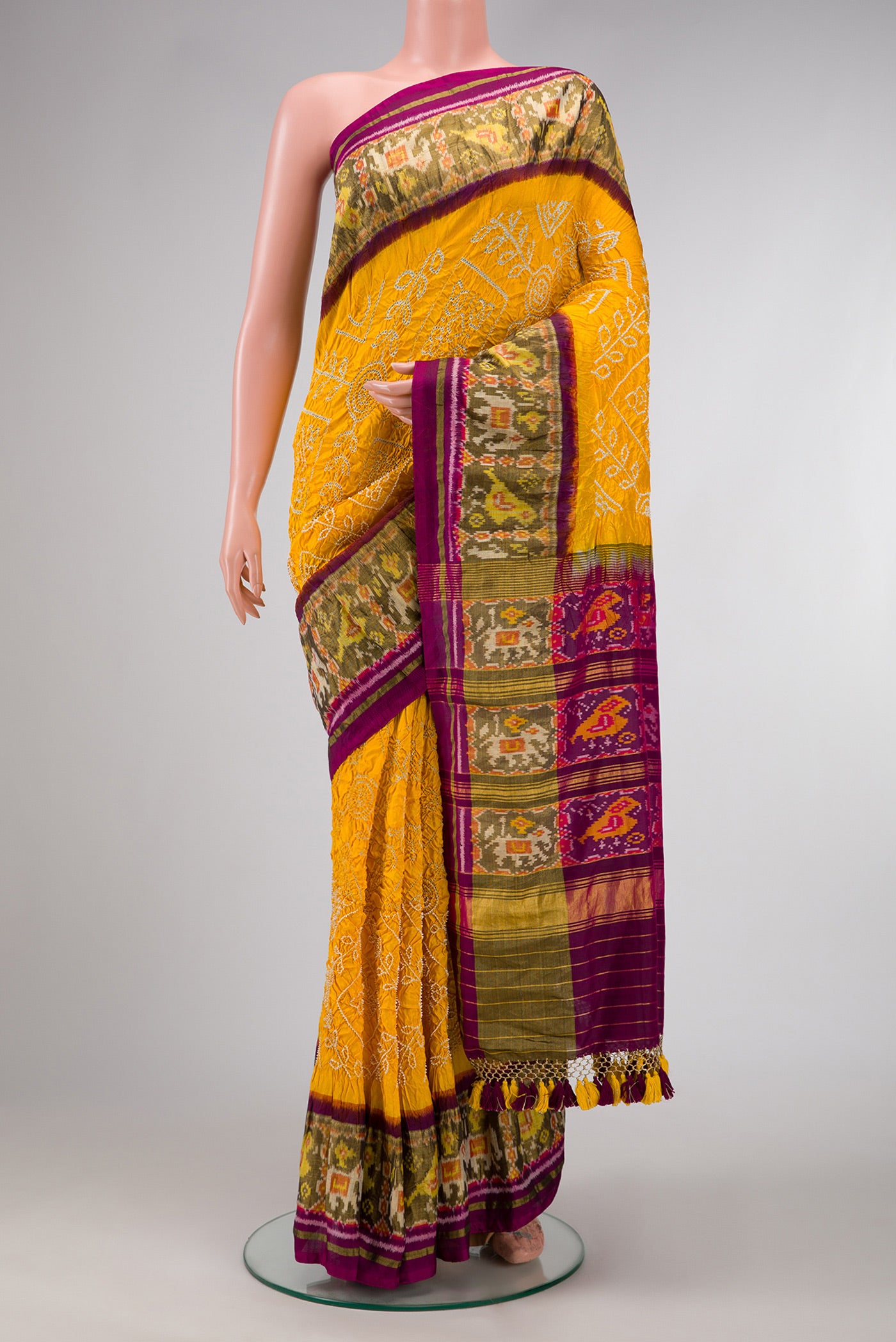 Yellow Dual Tone Bandhani Silk Saree with Bandhani Print on the body and Ikat Border.  displayed on a mannequin