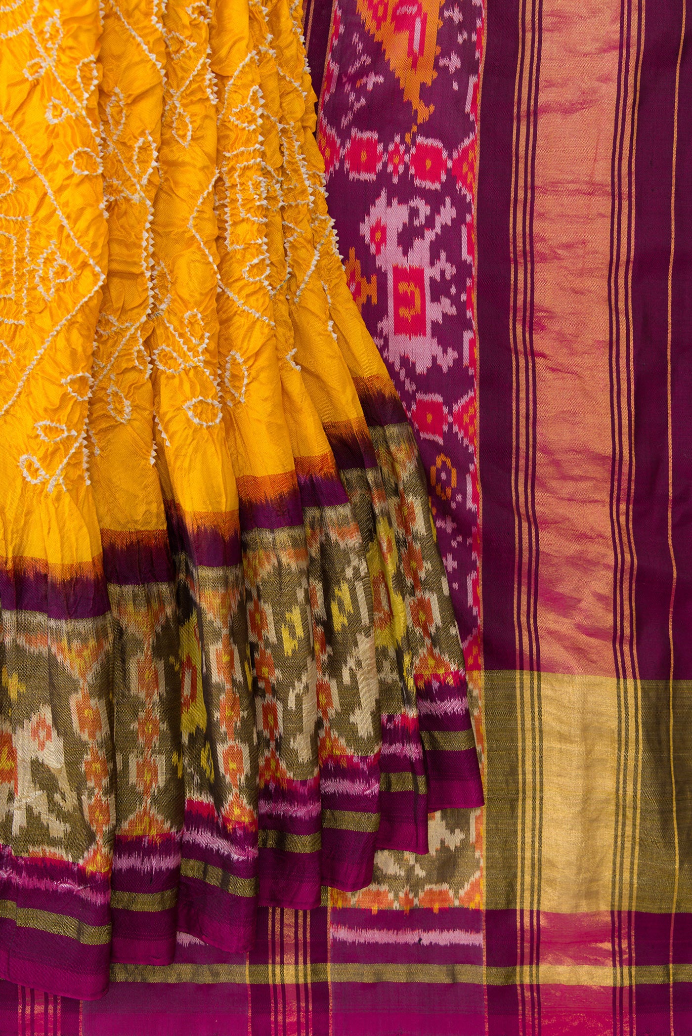 Pleats and pallu of Yellow Dual Tone Bandhani Silk Saree with Bandhani Print on the body and Ikat Border. 