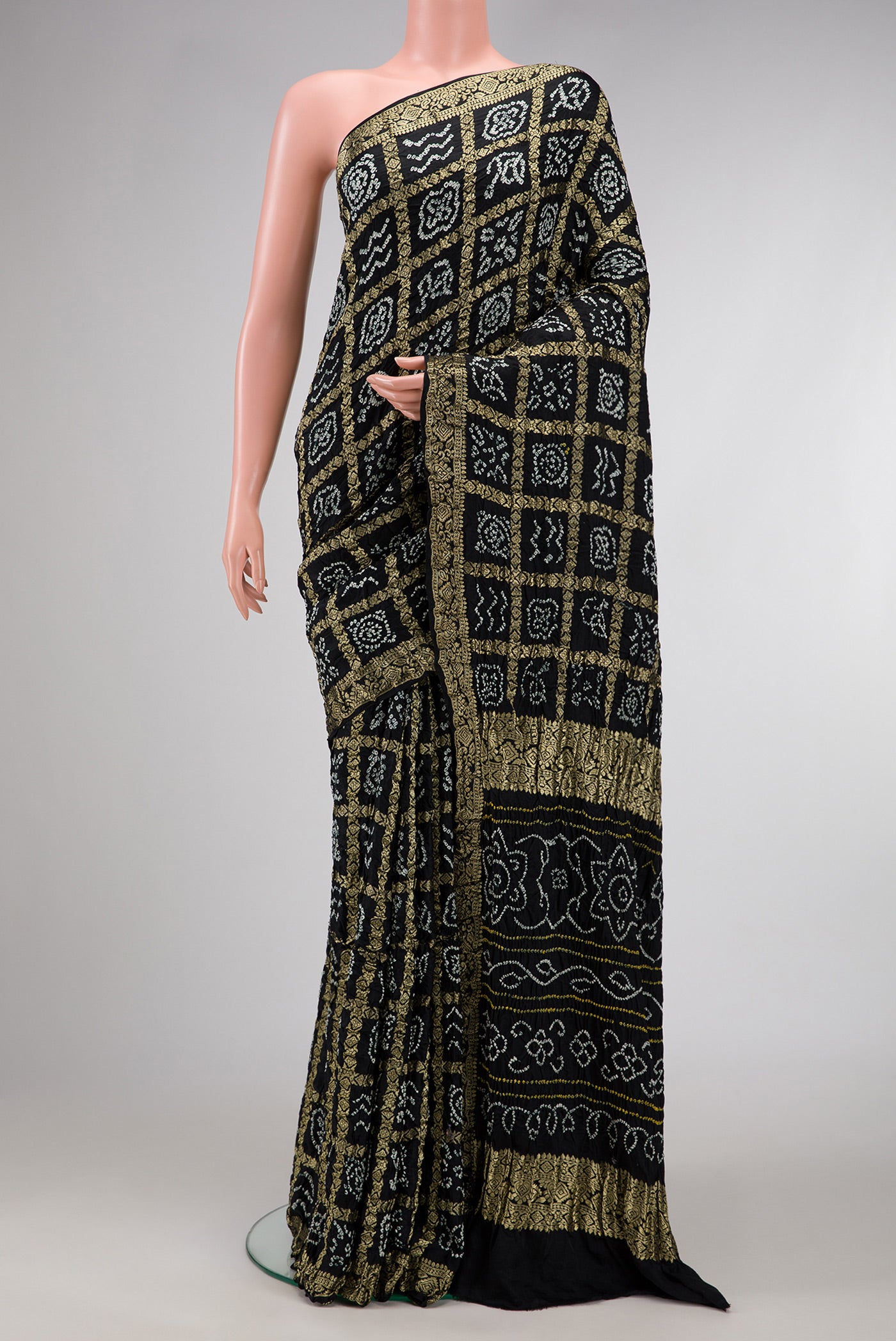 Black Dual Tone Bandhani Silk Saree with Bandhani Print on the body and Zari Border.  displayed on a mannequin