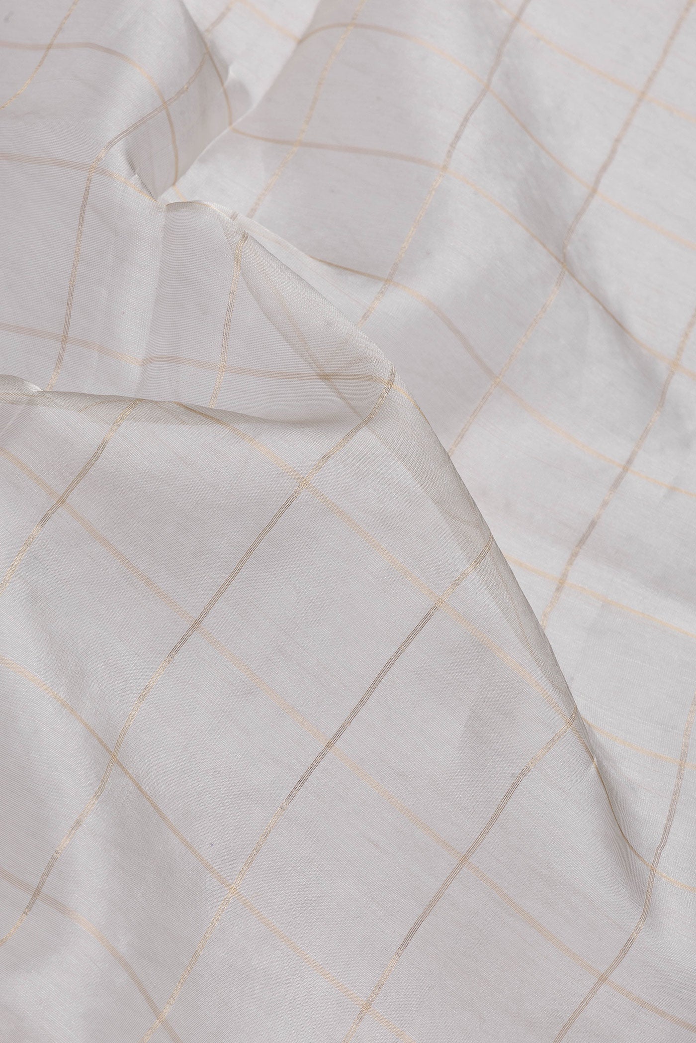 Close up of Silver Dual Tone Organza Silk Saree with Checked design on the body and Zari Border.  displaying folds