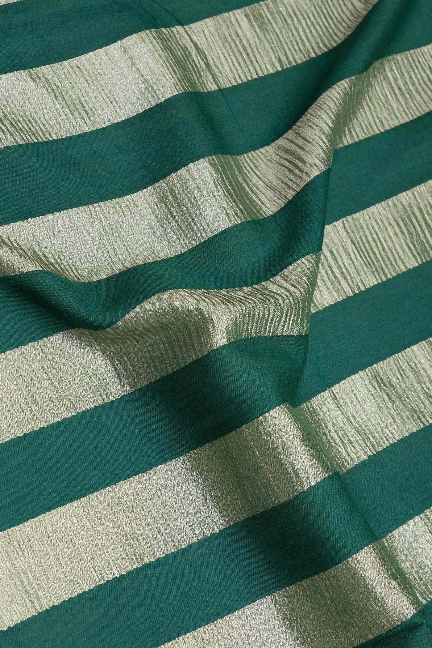 Close up of Green Tussar Silk Saree with Stripes on the body and Zari Border.  displaying folds