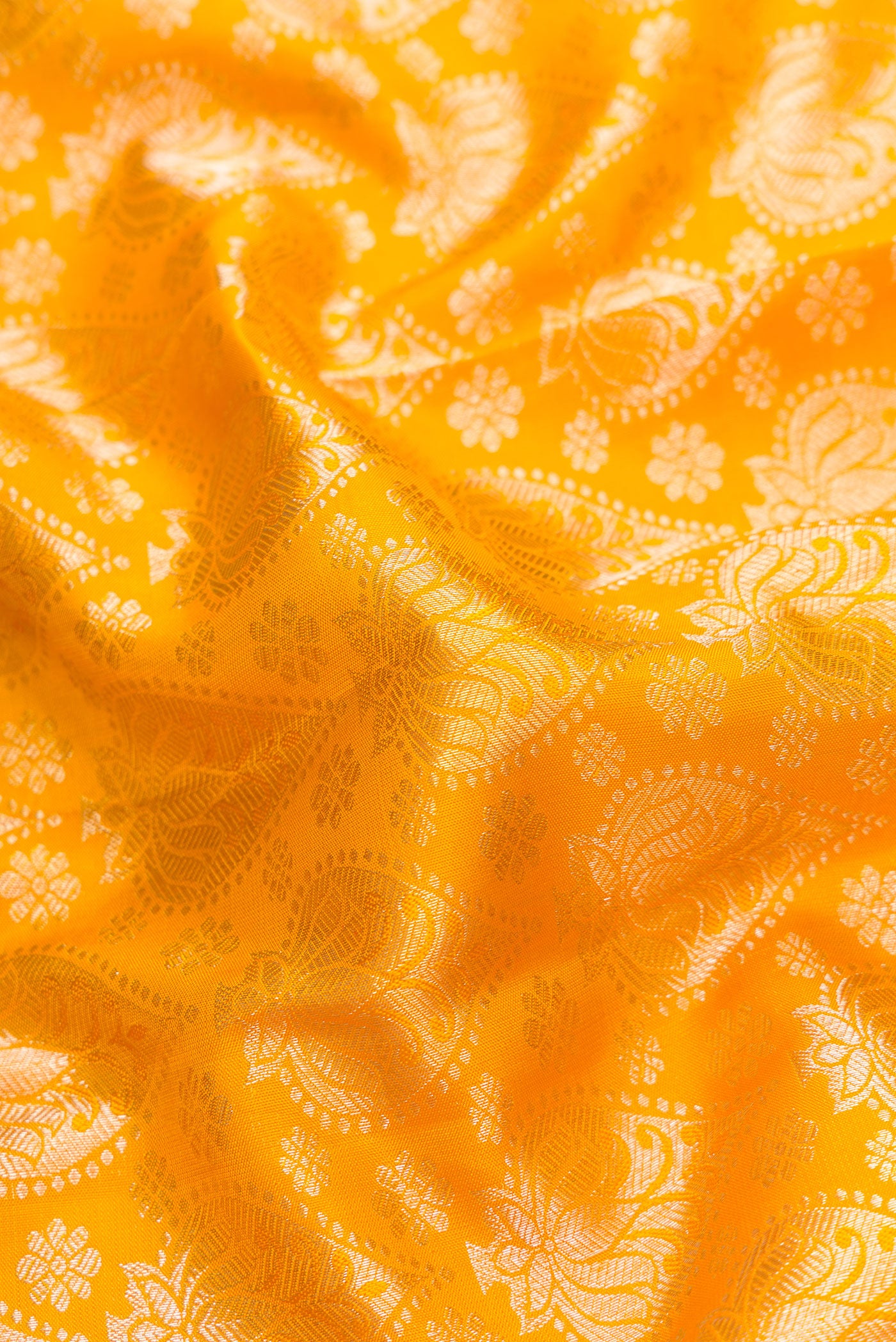 Close up of Mustard Dual Tone Kanjivaram Silk Saree with Zari Brocade on the body and Zari Border.  displaying folds