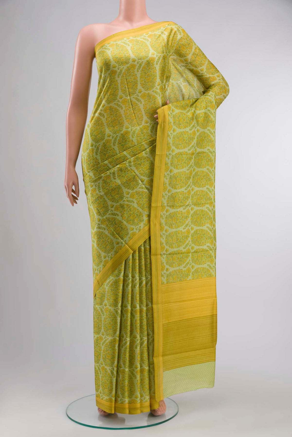 Green Printed Silk SareePrinted design on the body and Plain Border displayed on a mannequin