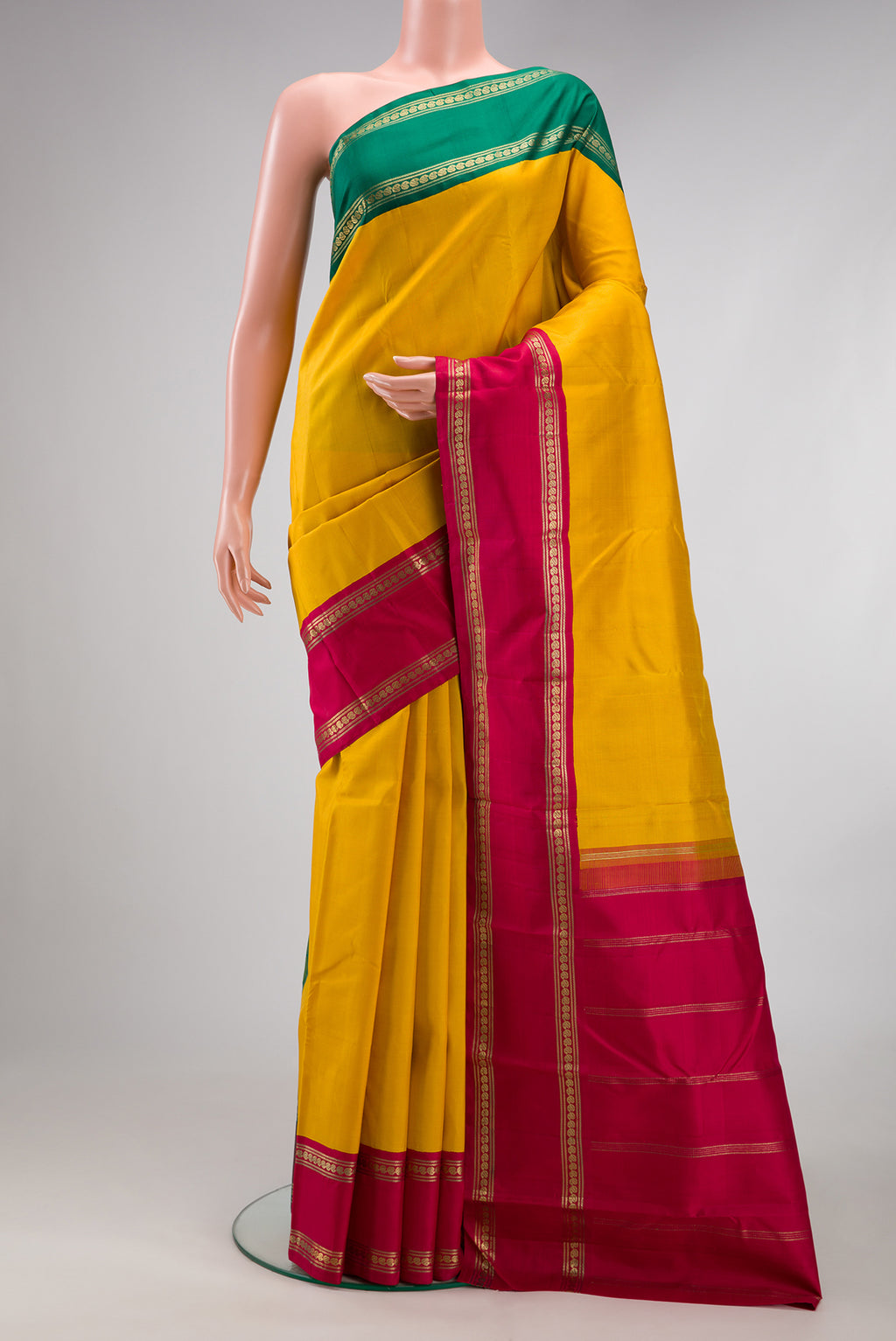 Pure Silk Pure Zari Mustard Kanjivaram Saree with Plain Body and Ganga Jamuna Border.  displayed on a mannequin