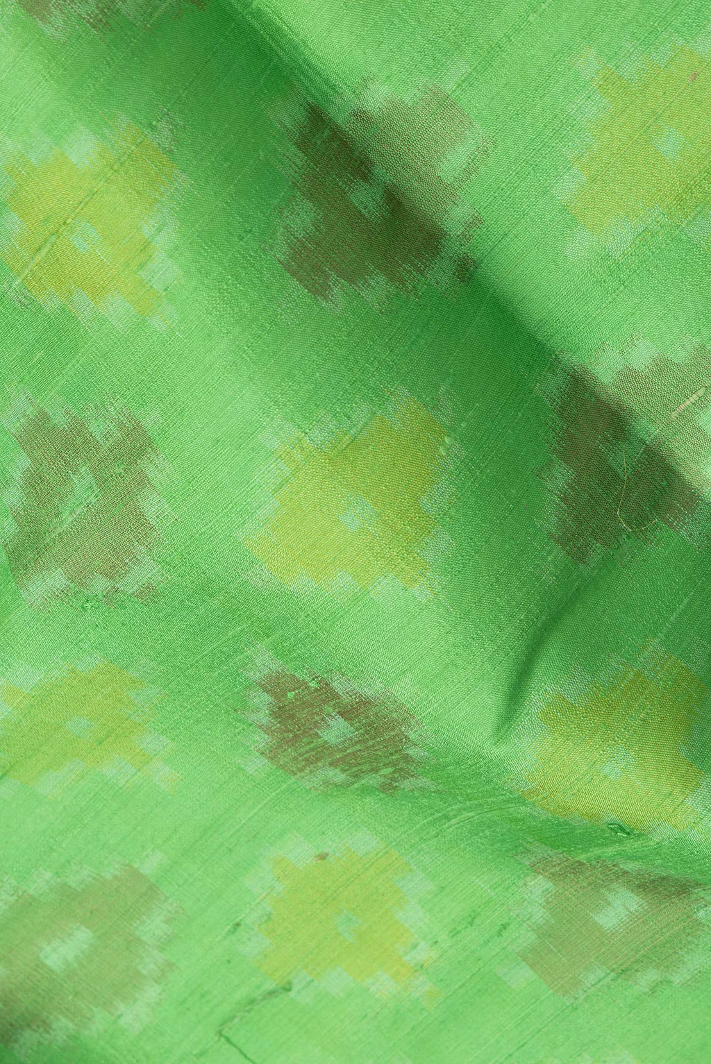 Close up of Green Dual Tone Raw Silk Saree with Ikat Print on the body and Zari Border.  displaying folds