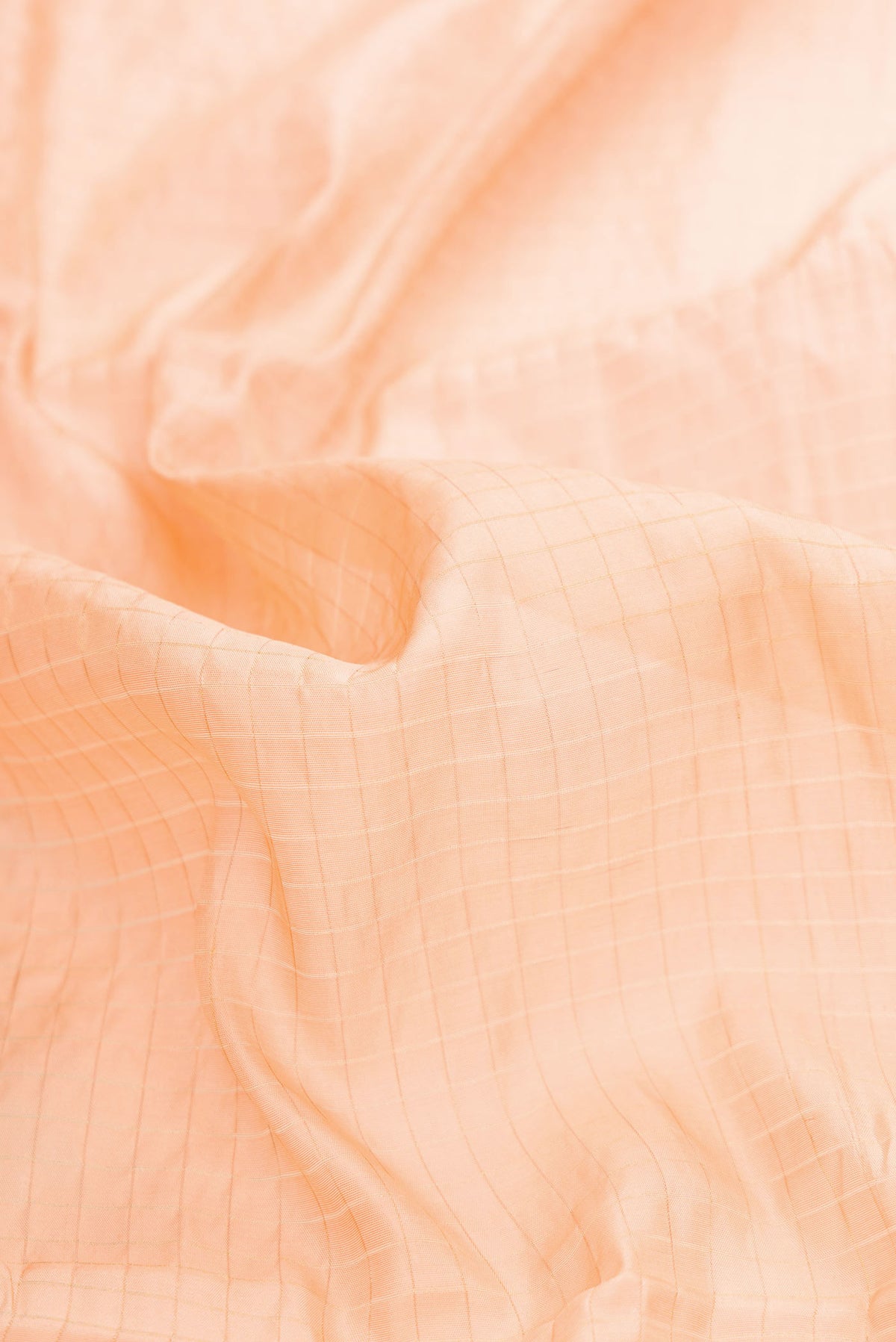 Close up of Orange Dual Tone Tussar Silk Saree with Stripes on the body and Zari Border displaying folds
