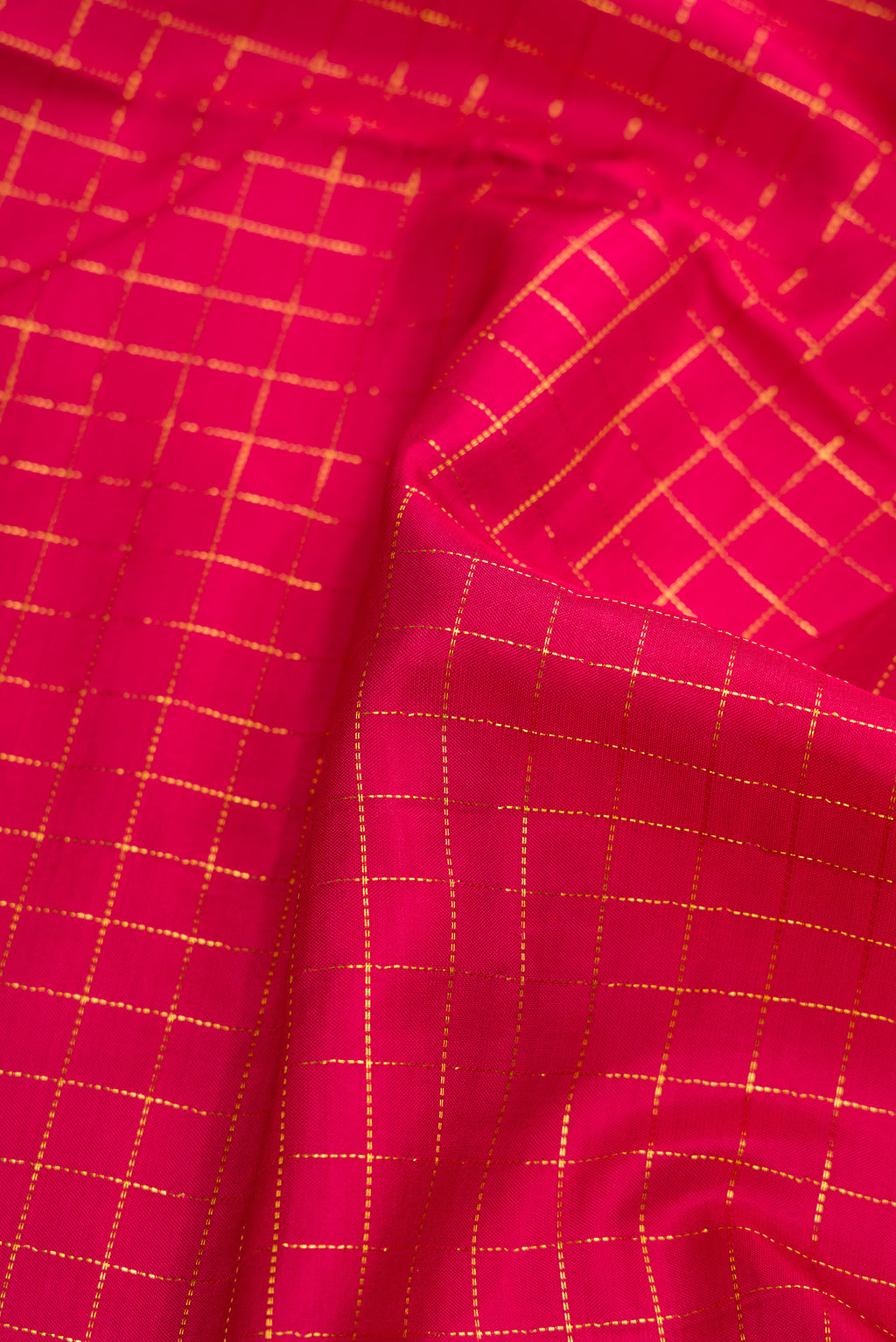 Close up of Red Dual Tone Kanchipuram Silk Saree with Checked design on the body and Zari Border.  displaying folds